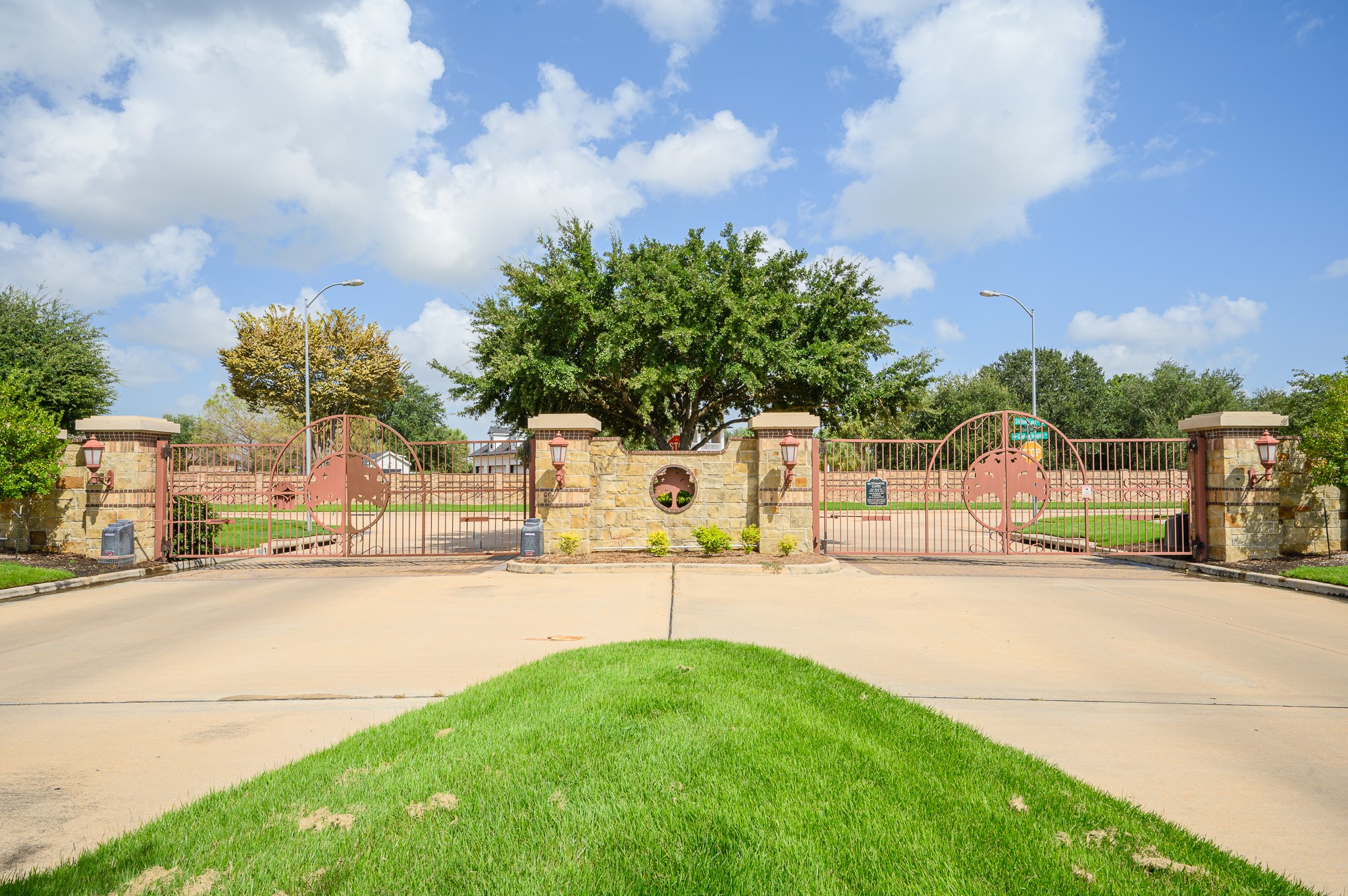 An elegant gated entrance with stately stone pillars and meticulous landscaping offers unmatched security and privacy.