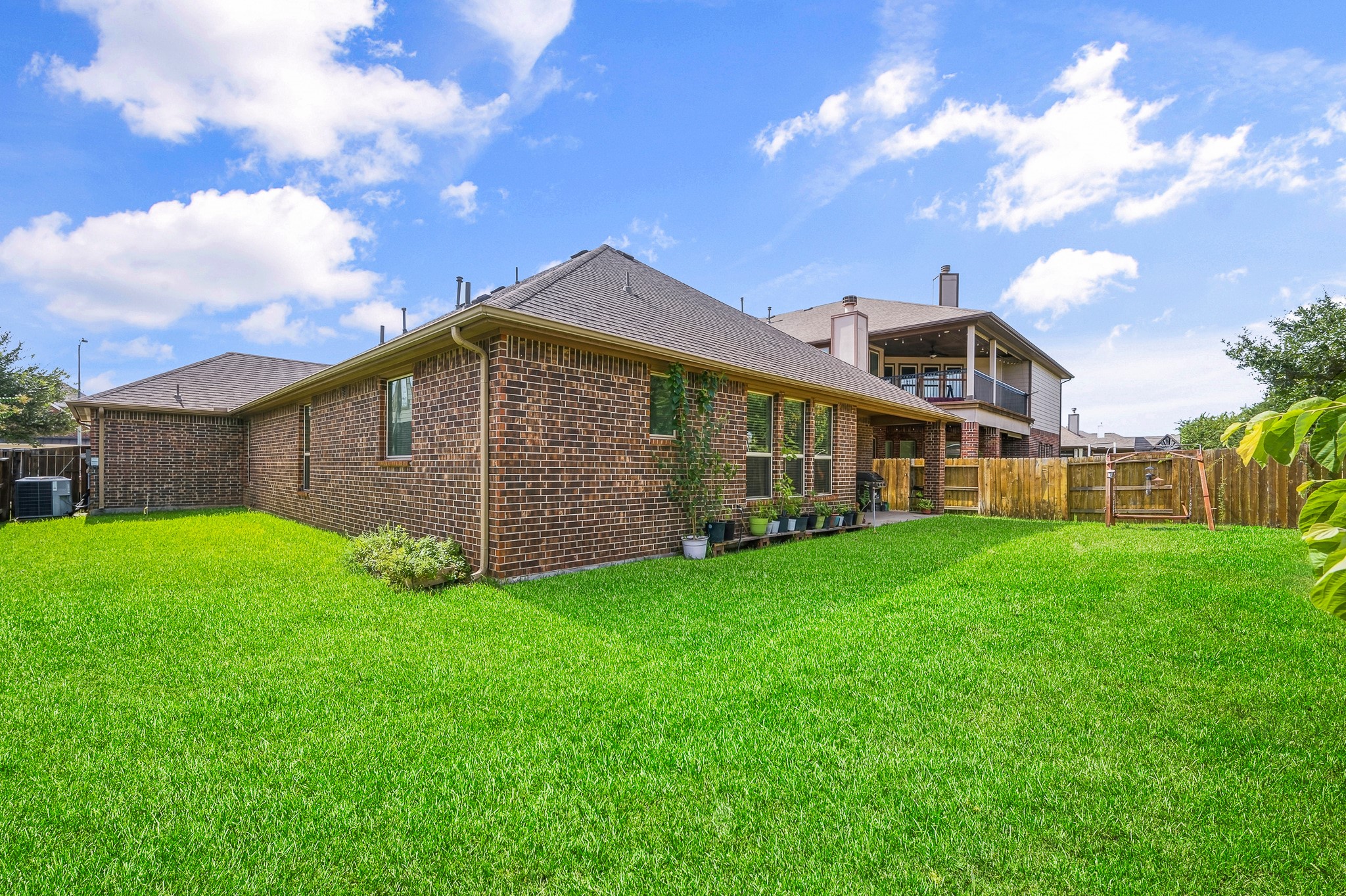 Charming brick home featuring an expansive, lush backyard perfect for outdoor activities and gatherings.