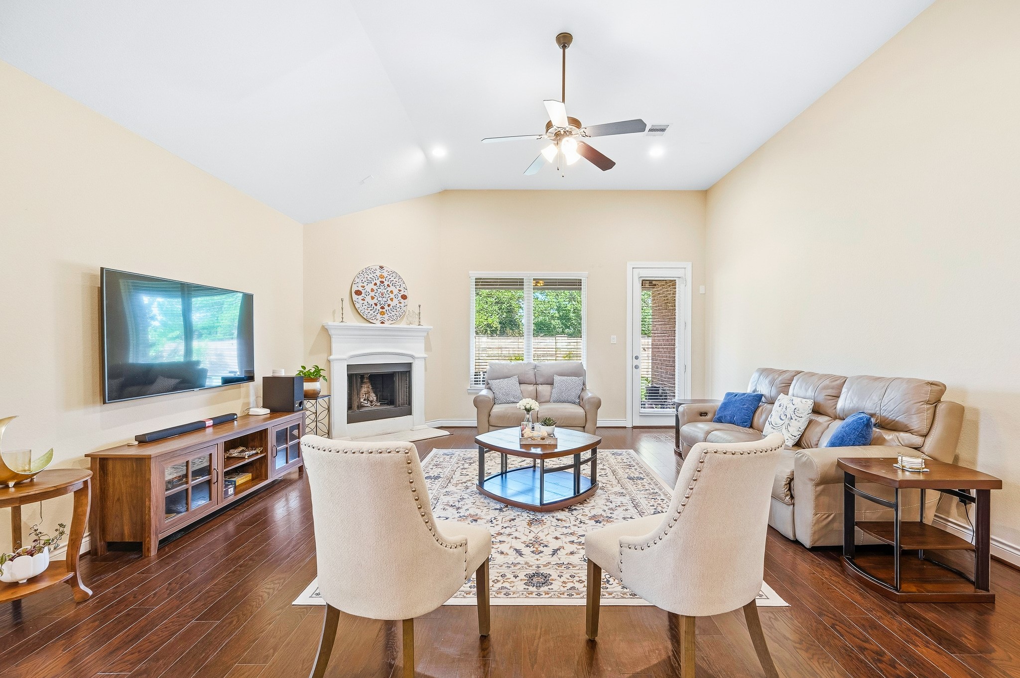 Expansive living room with soaring ceilings, a welcoming fireplace, elegant seating, and large windows that flood the space with natural light.