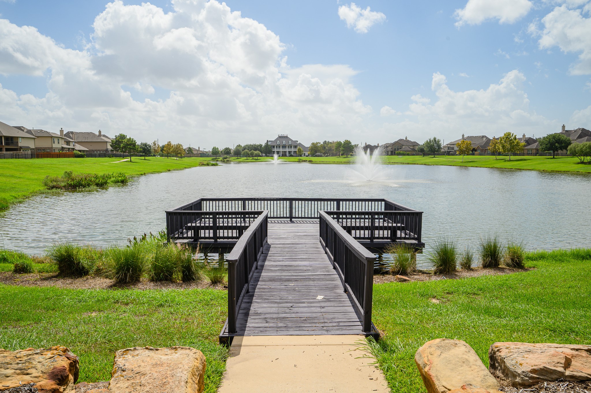 Embrace tranquil waterfront living with serene lake views, a central fountain, private dock, and lush greenery, perfect for relaxation and connecting with nature.
