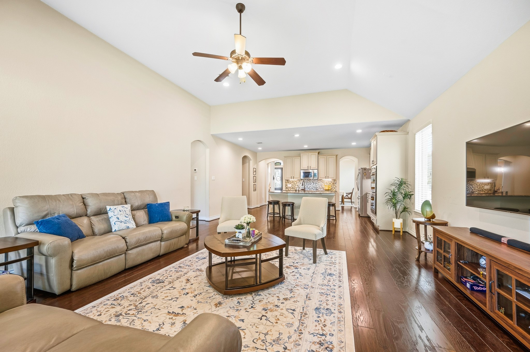 Discover the perfect blend of elegance and functionality in this spacious living area, featuring high ceilings, hardwood floors, and an open layout seamlessly connecting to a modern kitchenideal for entertaining and relaxation.