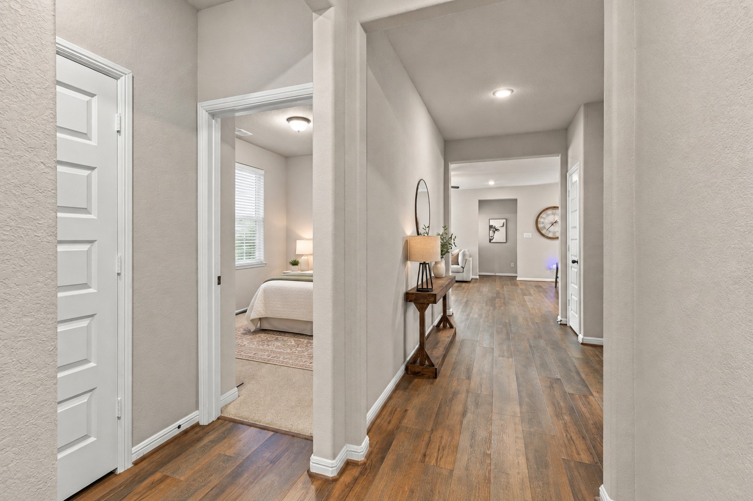 Defined entry foyer with wood-look flooring, neutral finishes, and a hallway leading into the main living areas.