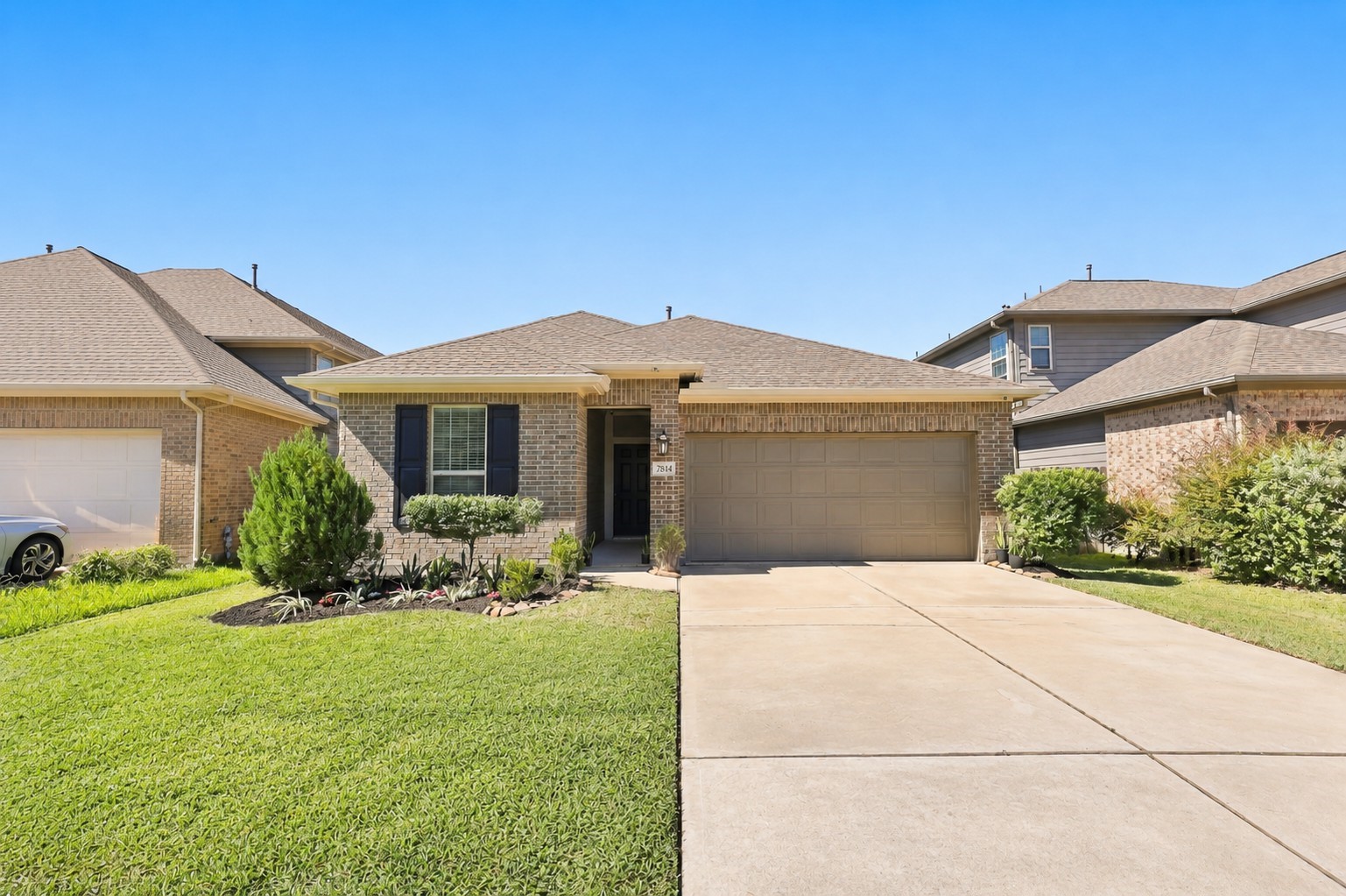 Welcome to 7814 Tindarey Maple Trace, a single-story brick home in Grand Vista with landscaped curb appeal and an attached 2-car garage.