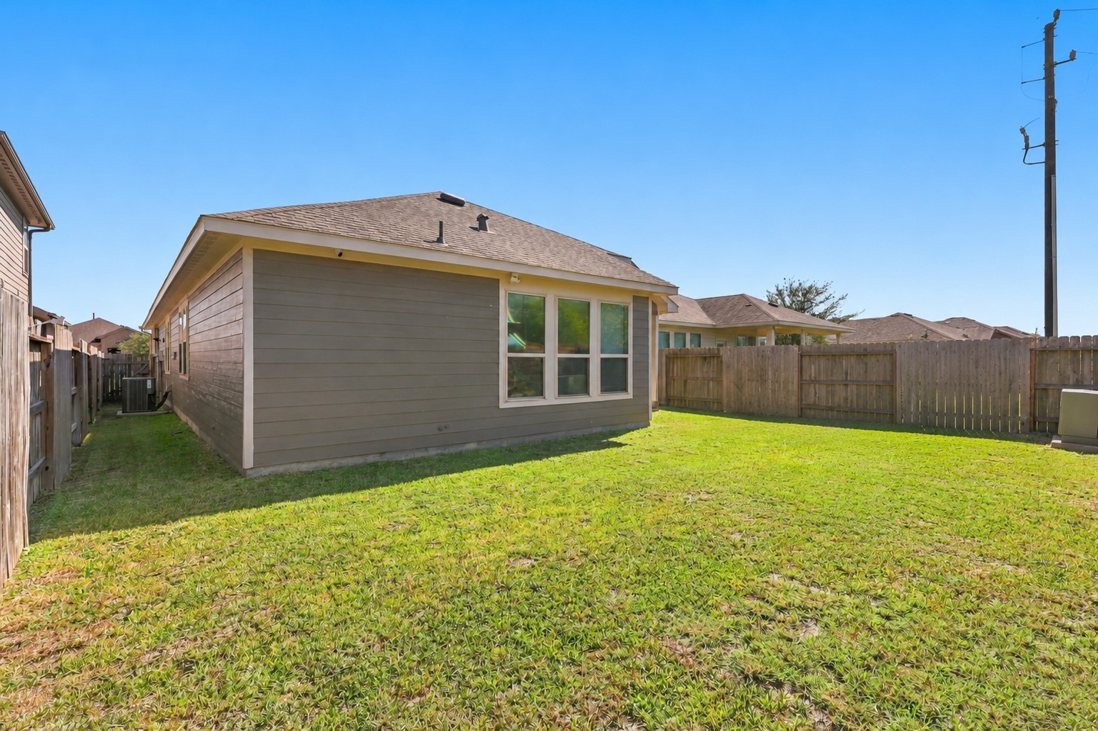 Wide rear yard with open lawn space and convenient access to the covered patio