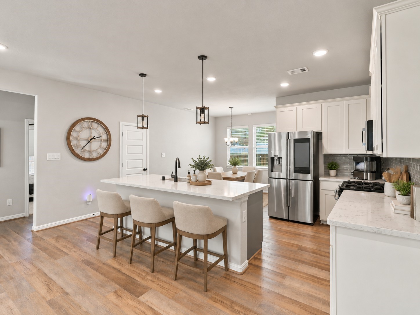 Open kitchen with a generous island, breakfast bar, white cabinetry, and an adjacent dining area.**Virtually staged
