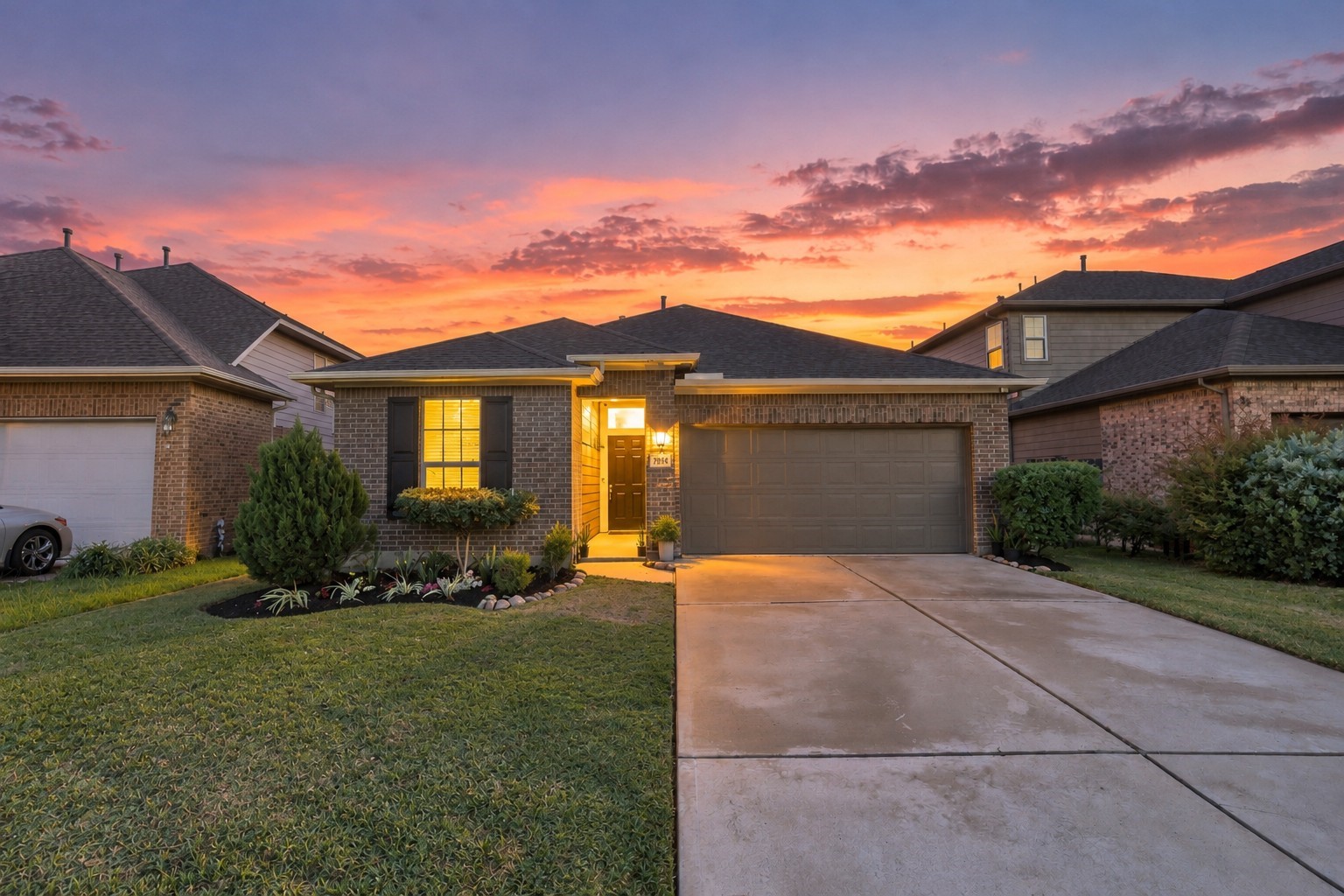 Inviting front elevation highlighted by exterior lighting, landscaped grounds, and a welcoming covered entry.