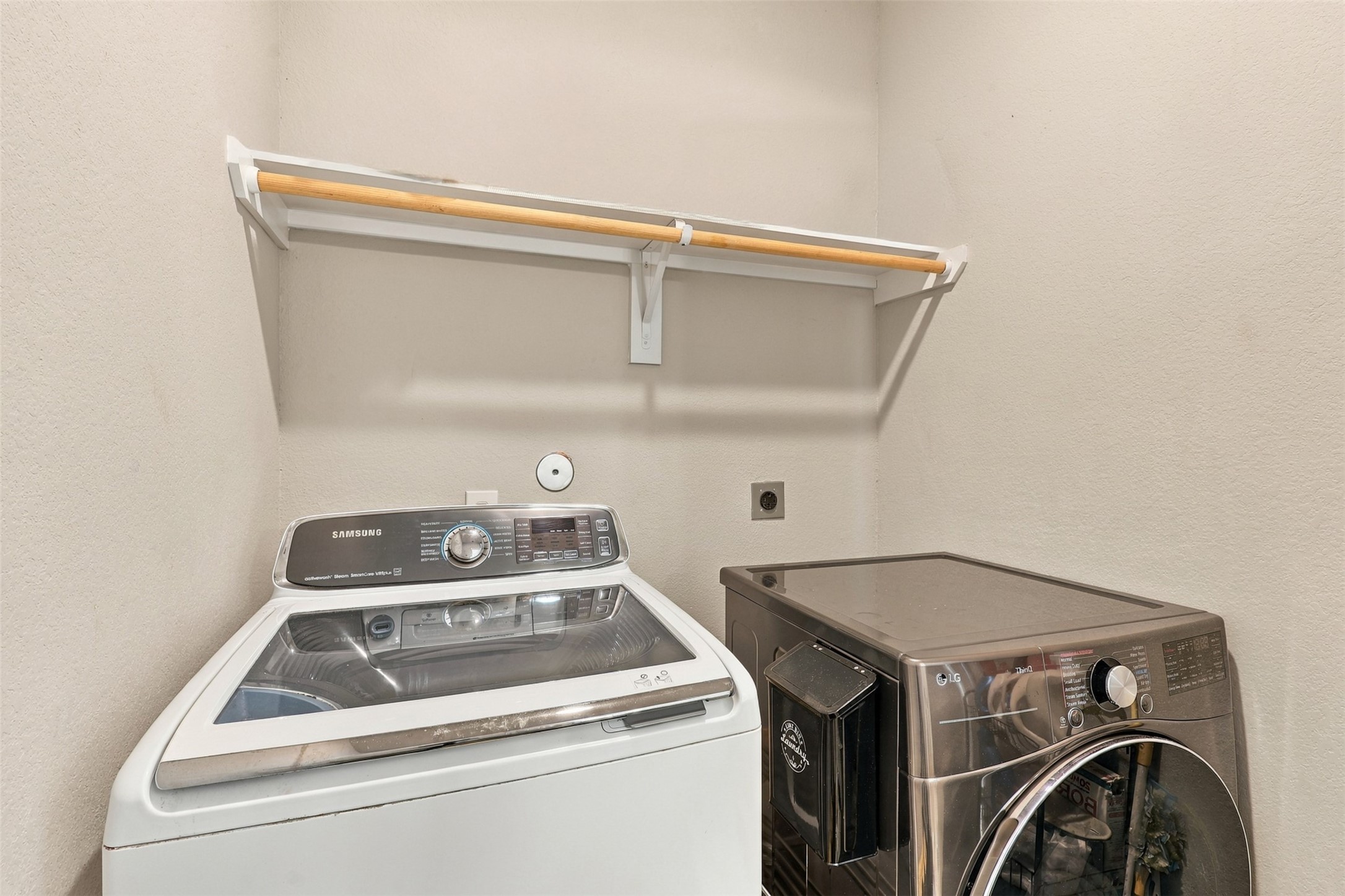 Separate laundry room with washer and dryer hookups and overhead storage shelving.