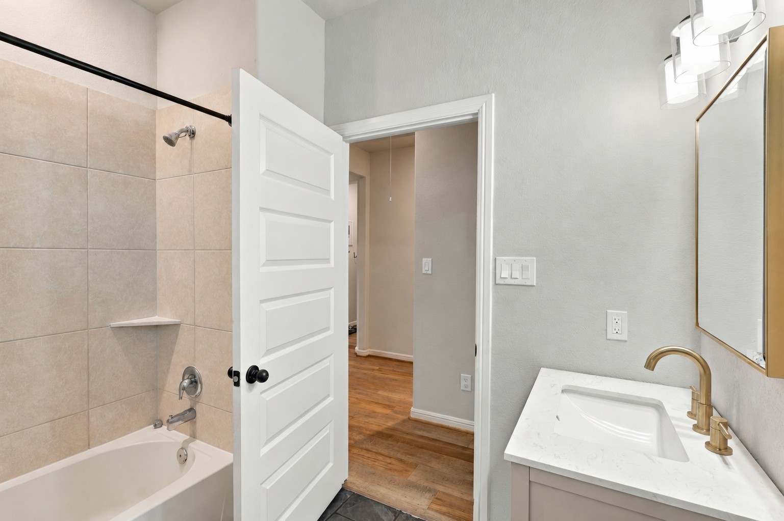 Full secondary bath with a tiled tub/shower combination and convenient hallway access.