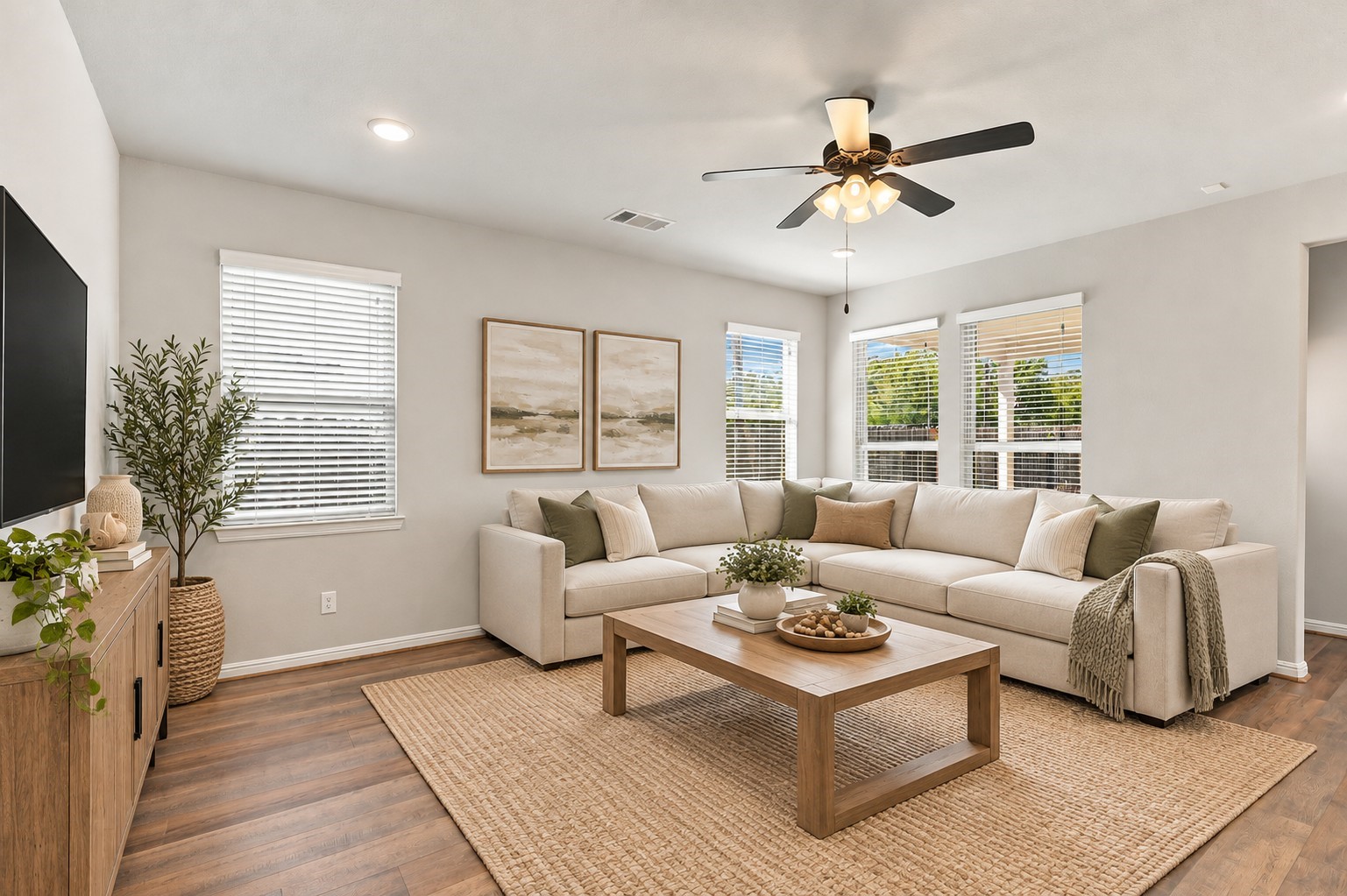 Spacious, naturally lit family room with multiple windows, a ceiling fan, and an open layout ideal for everyday living.**Virtually staged