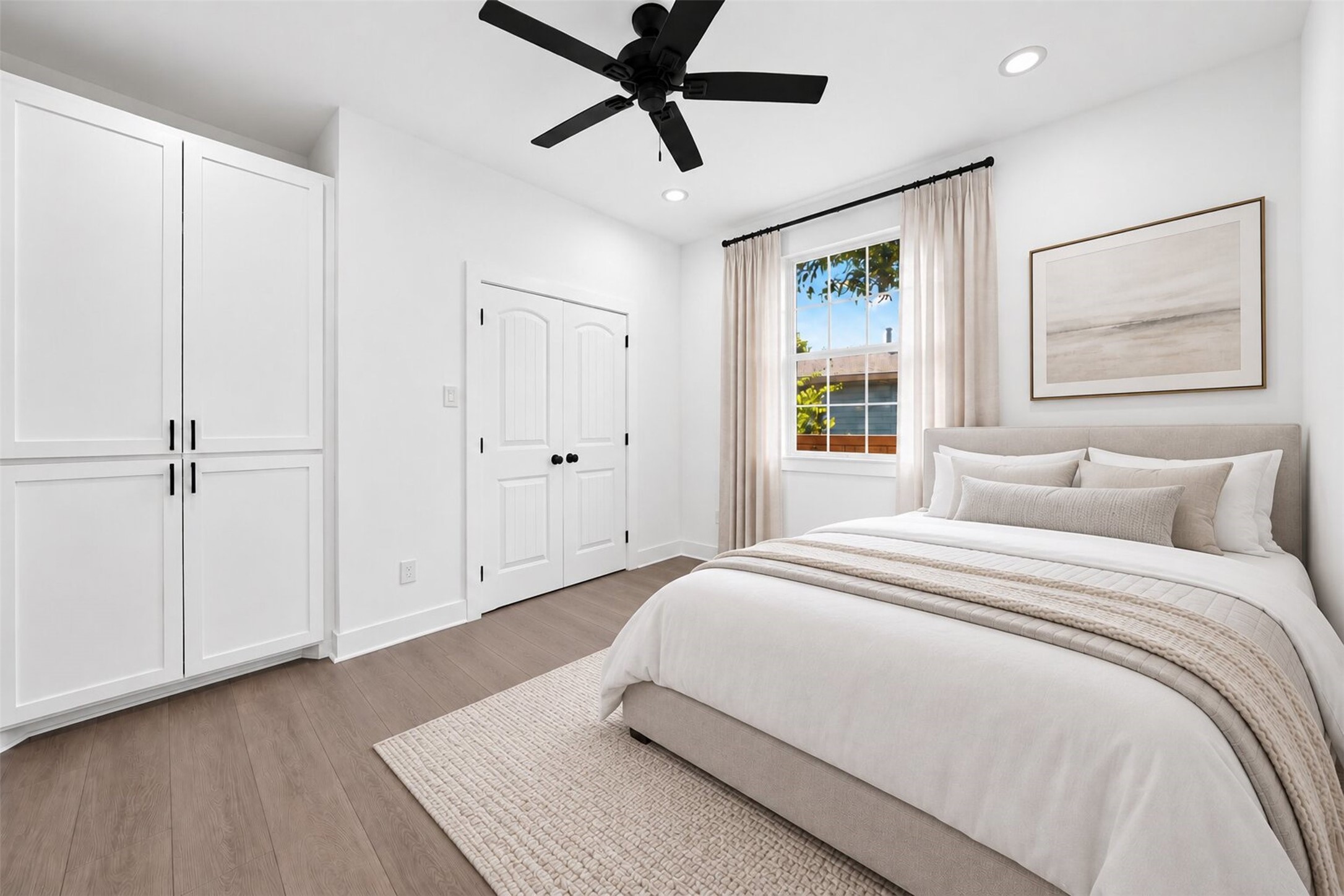 Bedroom has bright window, a contemporary ceiling fan, recess lighting and calming neutral walls. Picture a snug bed and chic furniture, all with a lovely view the backyard. The space is virtually staged.