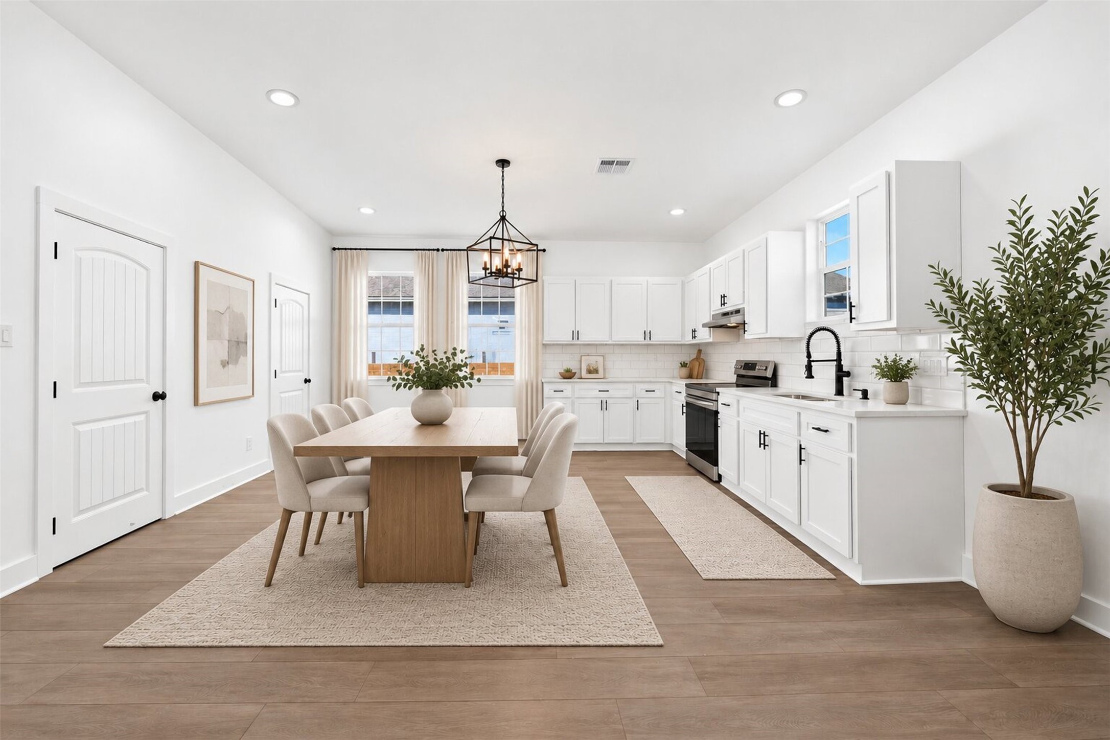 The kitchen boasts contemporary white cabinetry,stainless steel appliances, and laminate flooring. It is bright and spacious, featuring recessed lighting and a large windows positioned above sink and adjacent to breakfast area. The kitchen boasts contemporary white cabinetry,stainless steel appliances, and laminate flooring. It is bright and spacious, featuring recessed lighting and a large windows positioned above sink and adjacent to breakfast area.