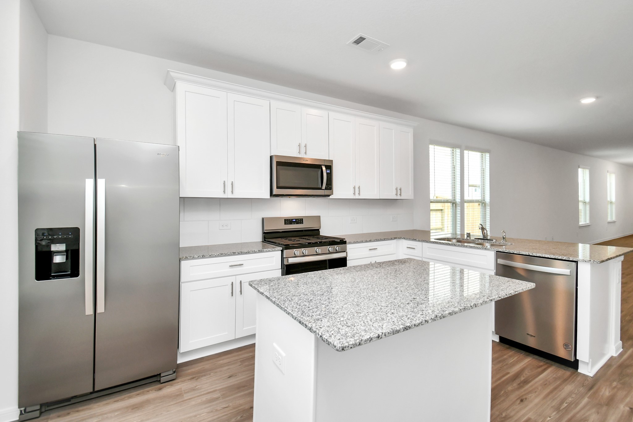 Kitchen fully equipped with stainless steel appliances including side-by-side refrigerator.