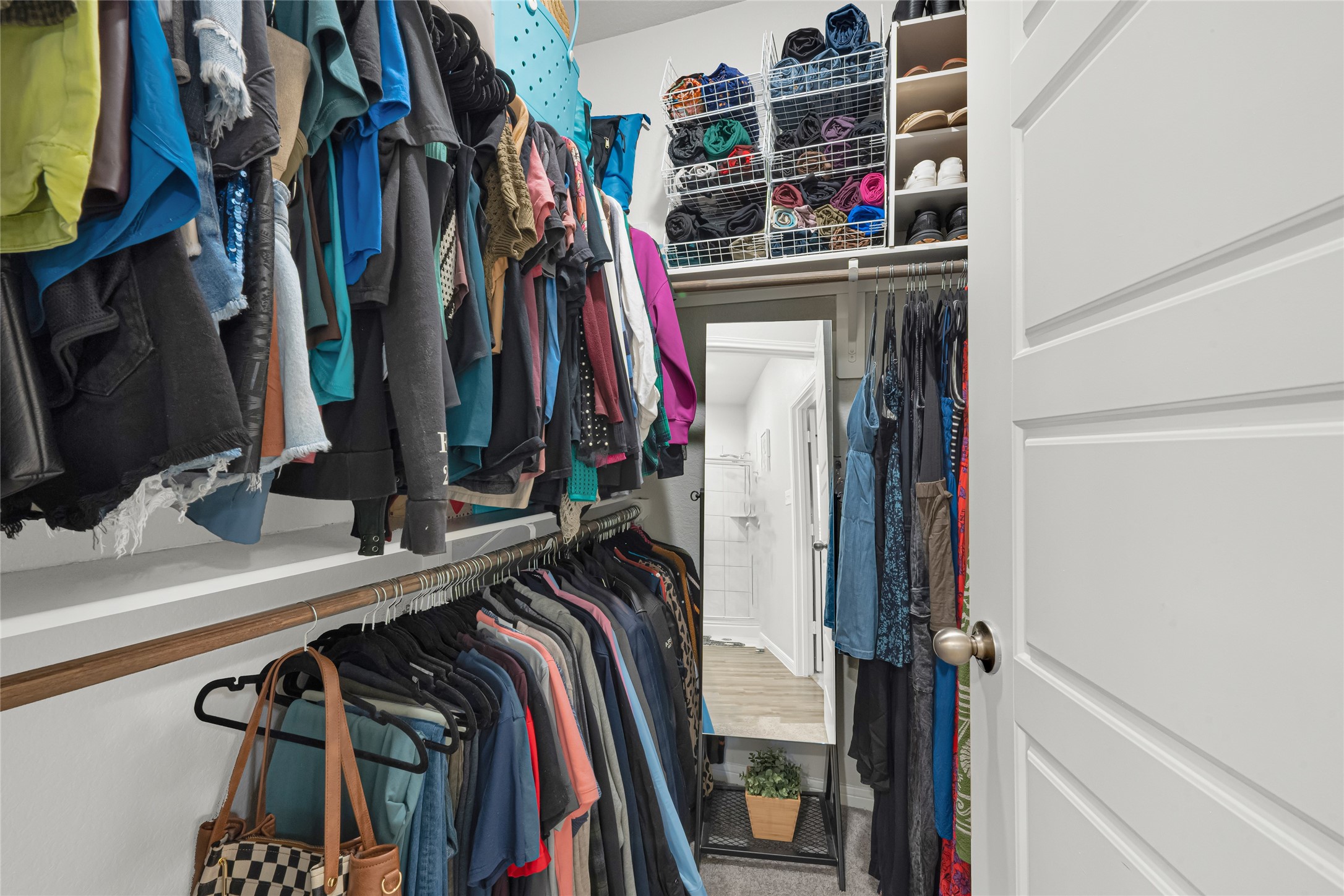 This generous walk-in closet features ample hanging space and built-in shelving  plenty of room to stay organized and keep everything in its place.