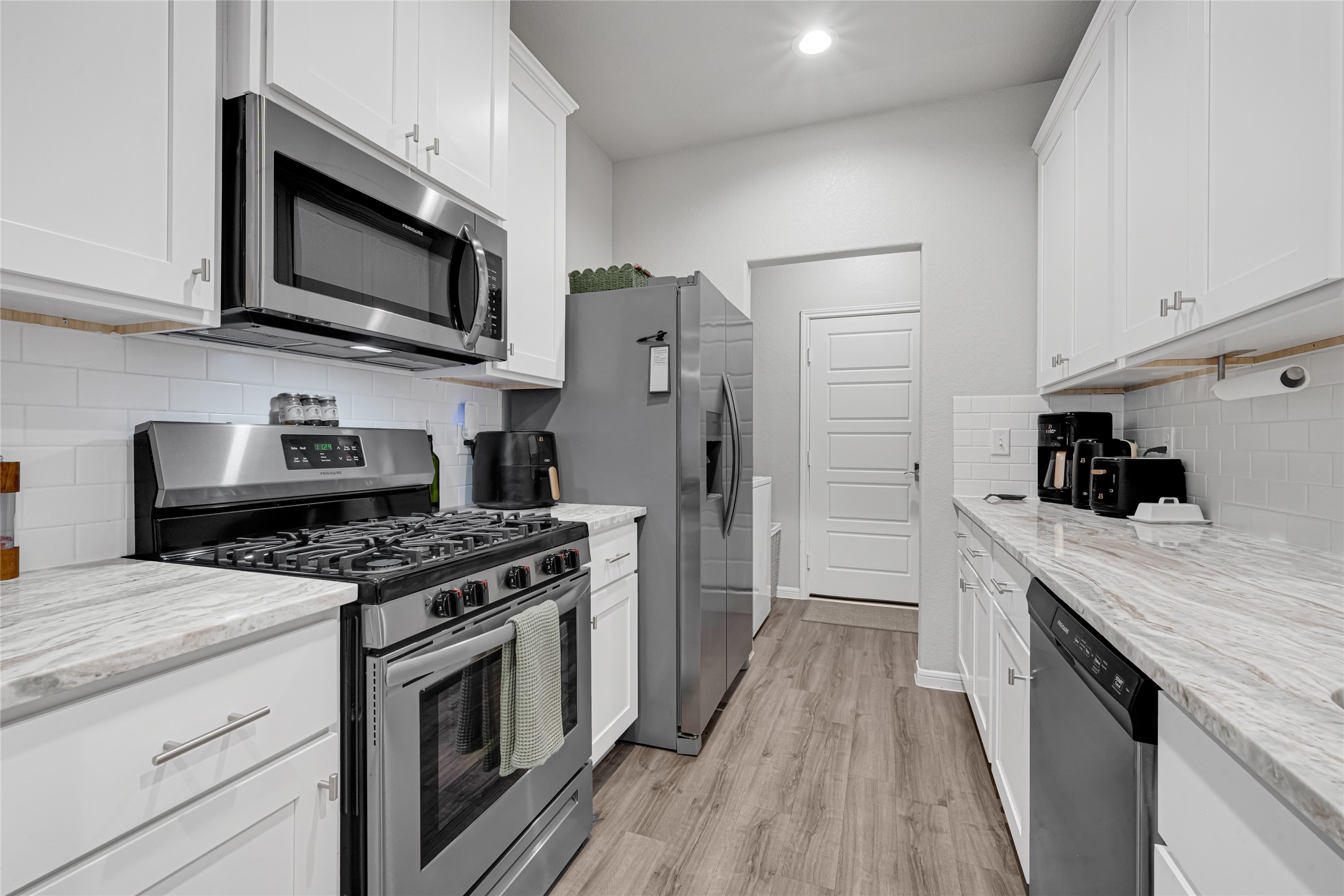 This designer kitchen is a DREAM KITCHEN including Stainless Frigidaire Appliance Package including free-standing 5 burner gas range, energy start dishwasher and microwave, Gorgeous Granite Countertops, 42" Birch cabinets with decorative crown molding, vinyl wood plank flooring continues through the kitchen creating continuity, light and bright recessed can lighting, Microwave/cooktop vented to the outside, and a generously sized pantry.