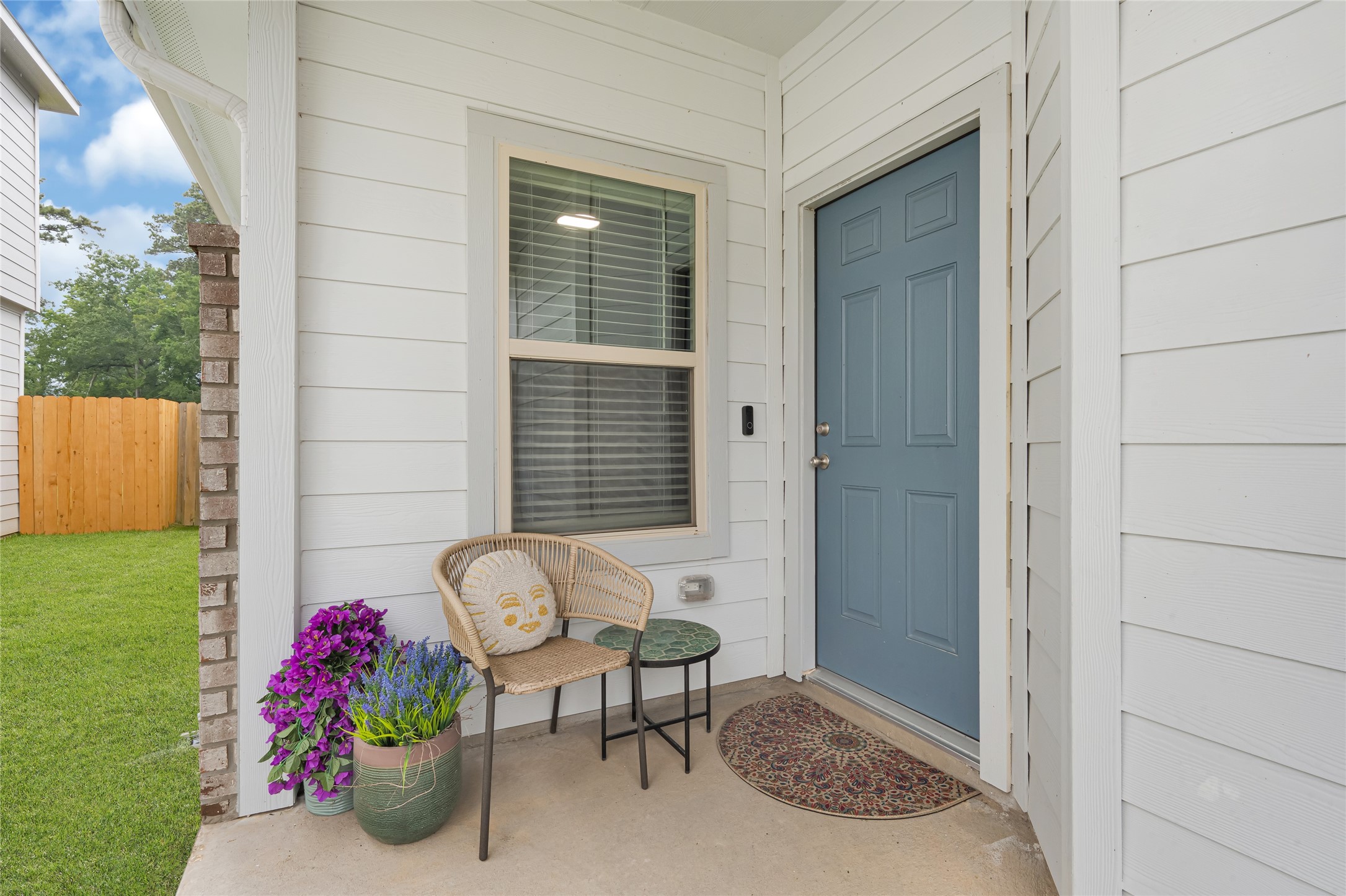 Step into charm with this inviting front porch featuring a stylish blue door and sleek satin nickel hardware, this home is complemented by the convenience of two hose bibs.