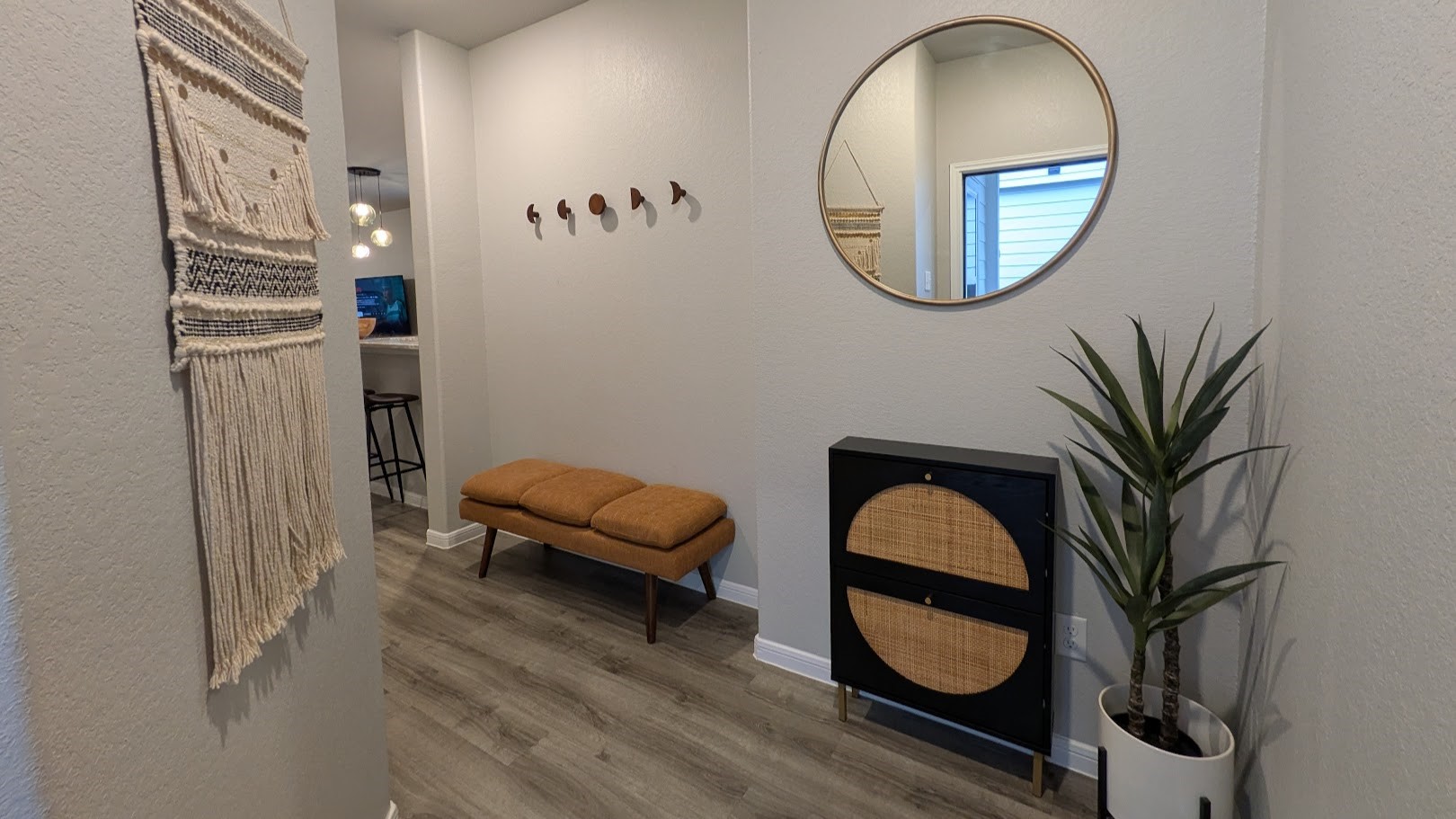 This entryway boasts a sleek, minimalist design with light gray walls and stylish vinyl wood plank flooring. This entry design offers privacy with its recessed door placement, helps to maintain the privacy of your living space.