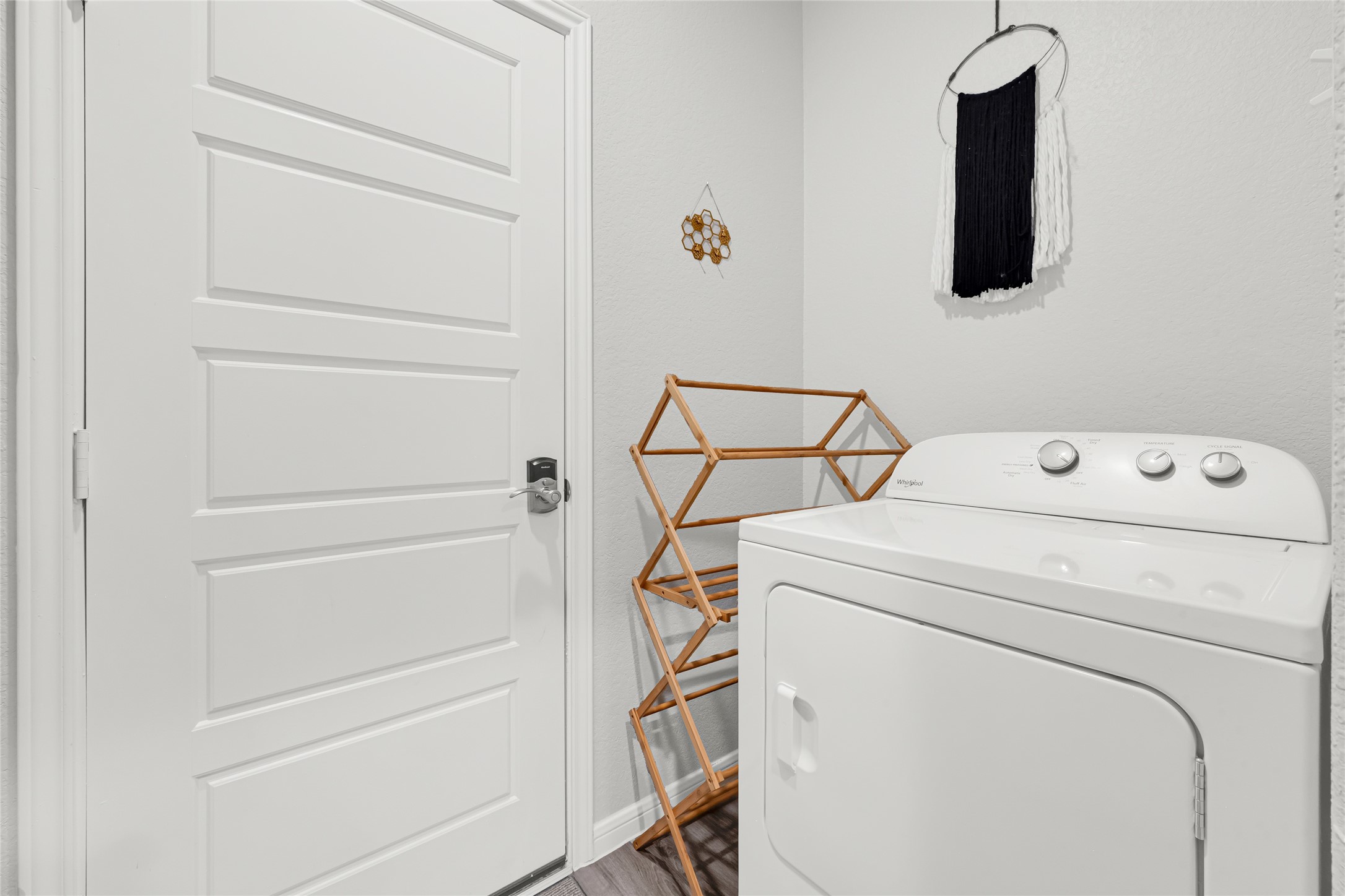 This sleek laundry room features a modern door connecting to the garage and seamlessly opens into the kitchen, offering both style and convenience.