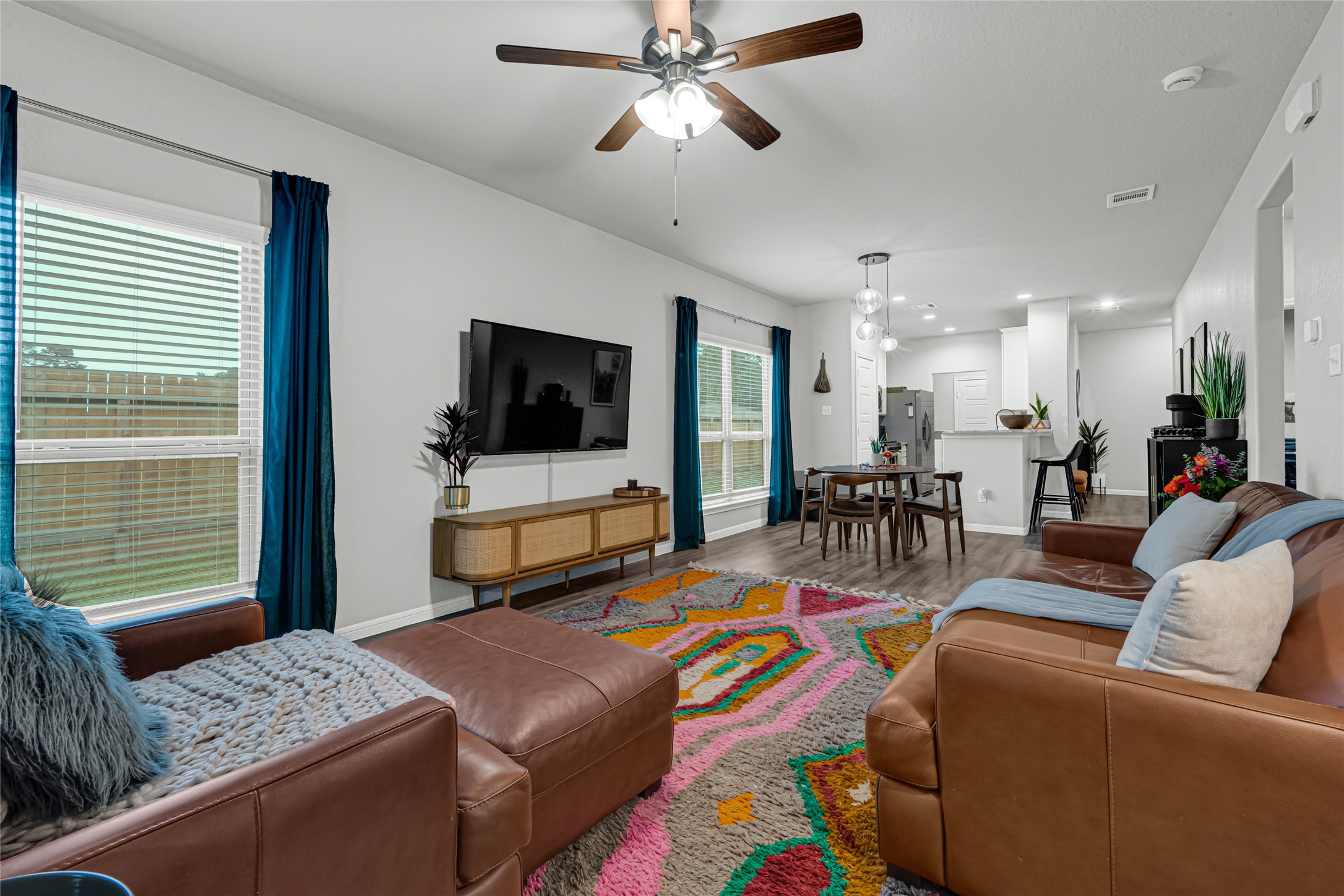 This inviting living space is all bathed in natural light from large windows, seamlessly connecting to the dining area and modern kitchen. This is a great open floor plan and the attention to detail is unsurpassed.