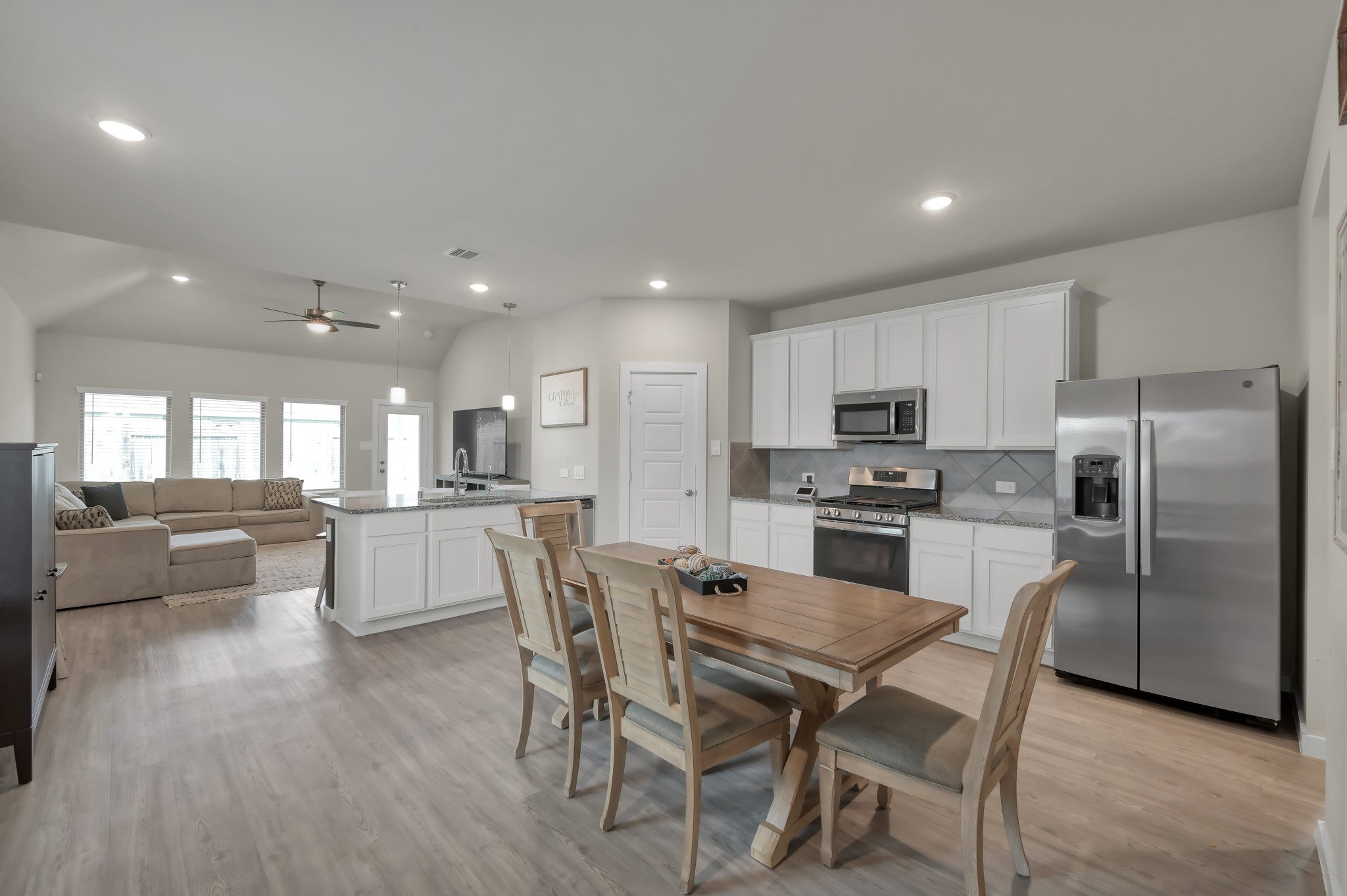 An open-concept kitchen and living area with modern appliances, a spacious dining table, and ample natural light. The layout is inviting and functional, perfect for both entertaining and everyday living.