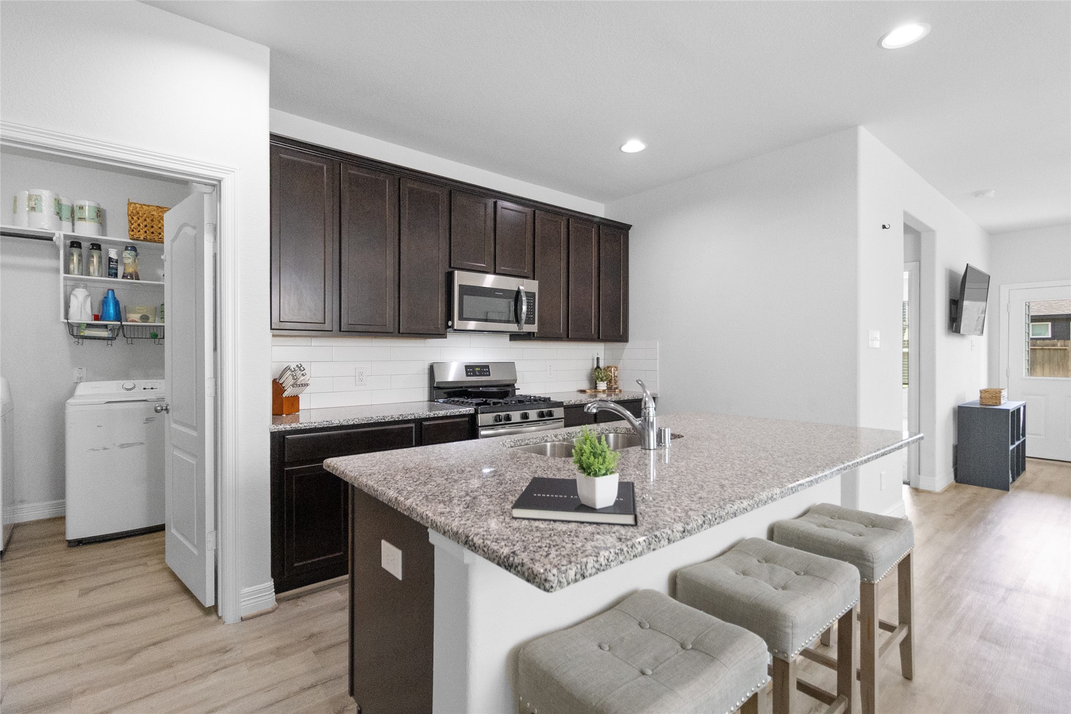 Your kitchen keeps everything within easy reach, pairing abundant cabinetry with a central island that makes cooking, serving, and gathering effortless.