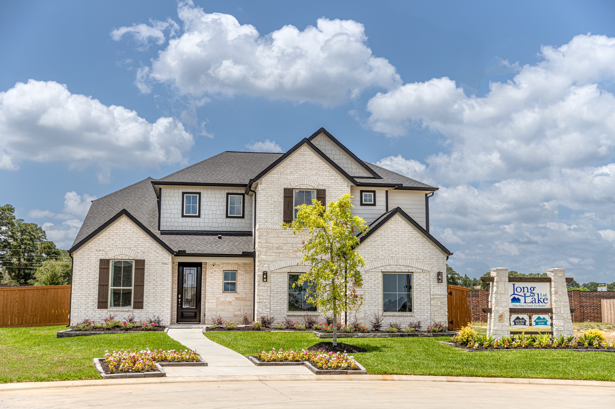 This home boasts lush green grass and meticulous landscaping. Its premium elevation showcases an exquisite blend of brick and stone features, complemented by modern coach lighting