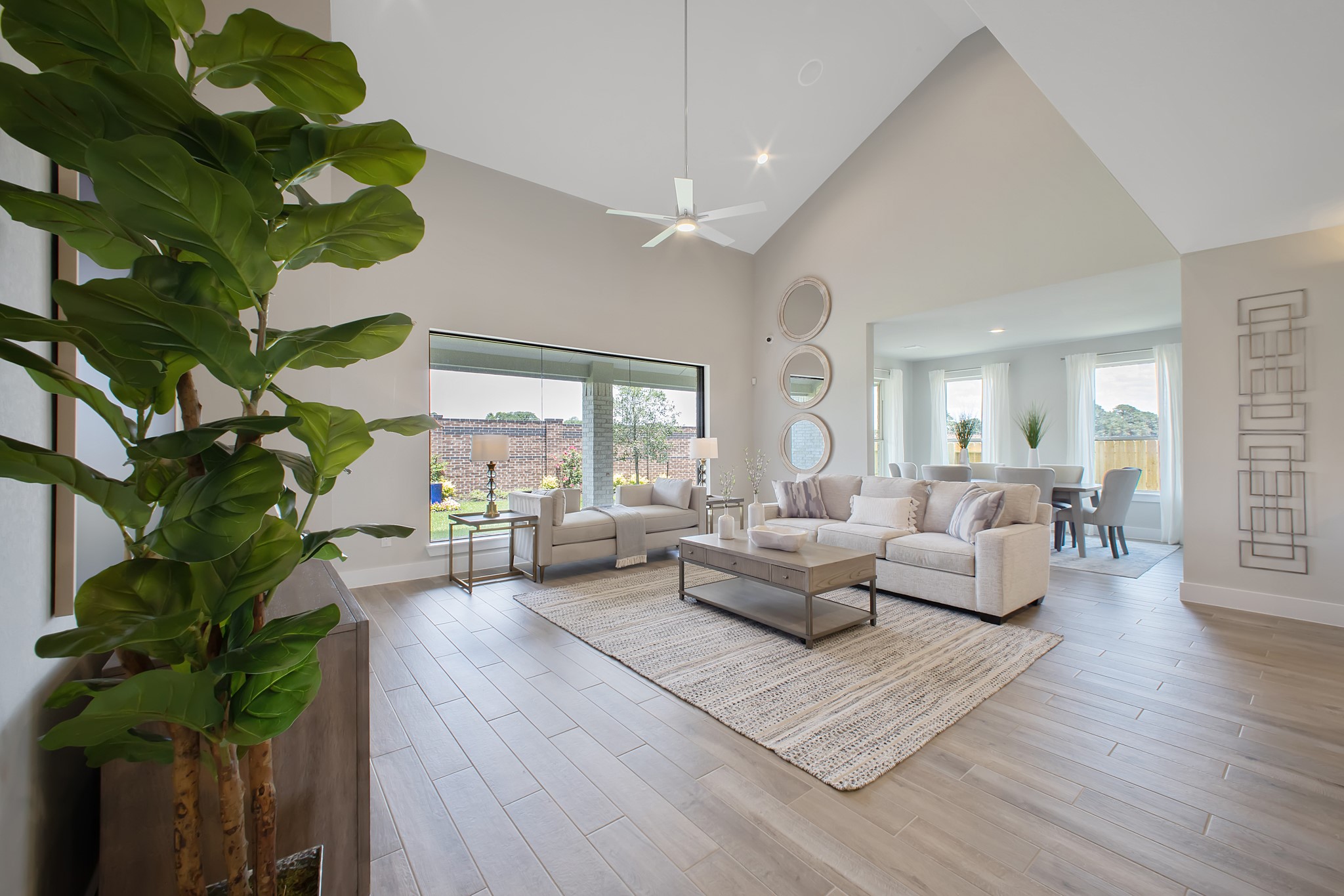 Family room flooded with natural light through the expansive windows.  The premium tile flooring adds a touch of luxury to the space, creating the perfect setting for relaxing moments and cherished gatherings with loved ones