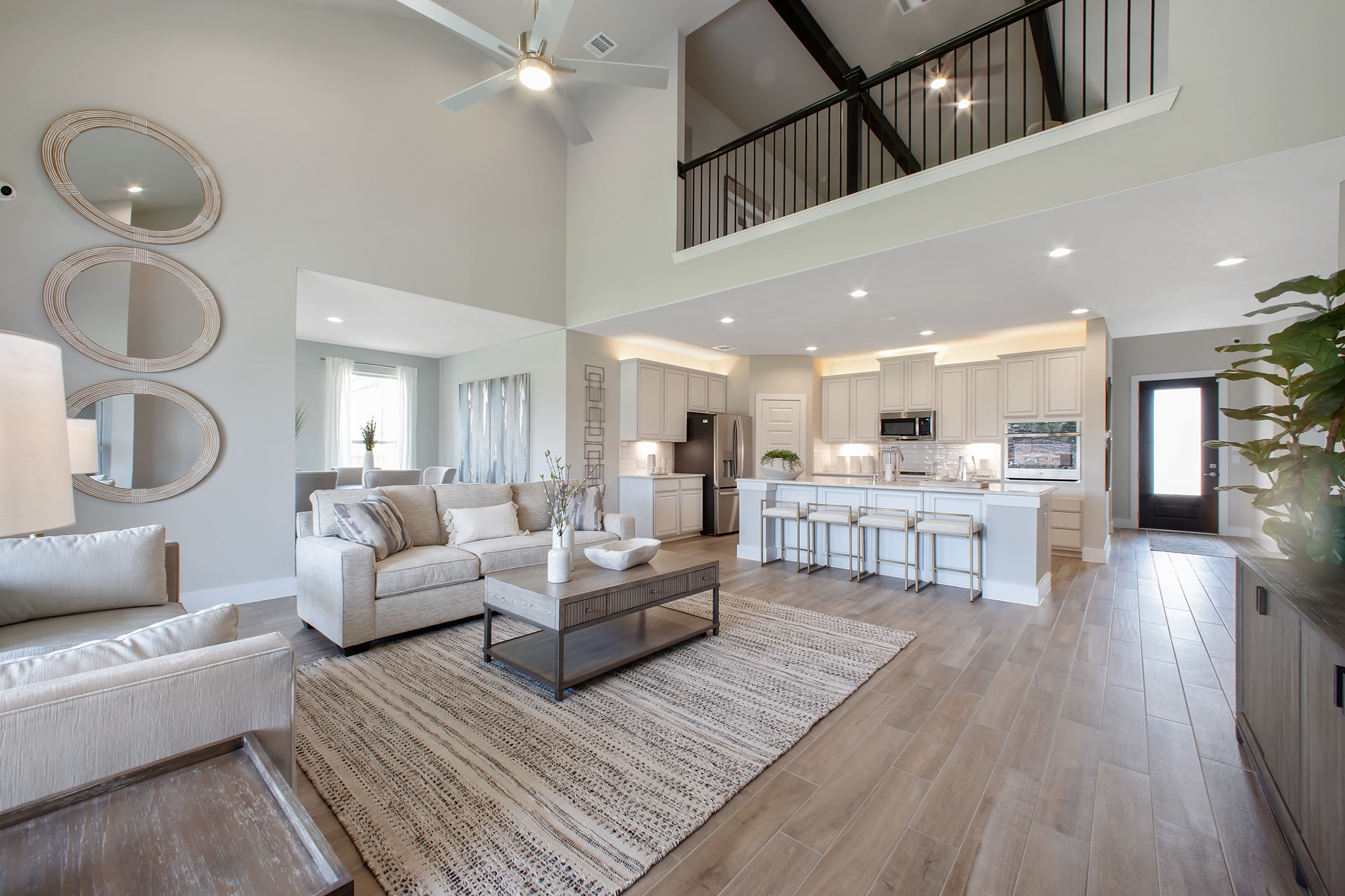 Gather the family and guests together in your lovely living room! Featuring soaring high ceilings, recessed lighting, ceiling fan, custom paint, gorgeous floors, and large windows that provide plenty of natural lighting throughout the day.