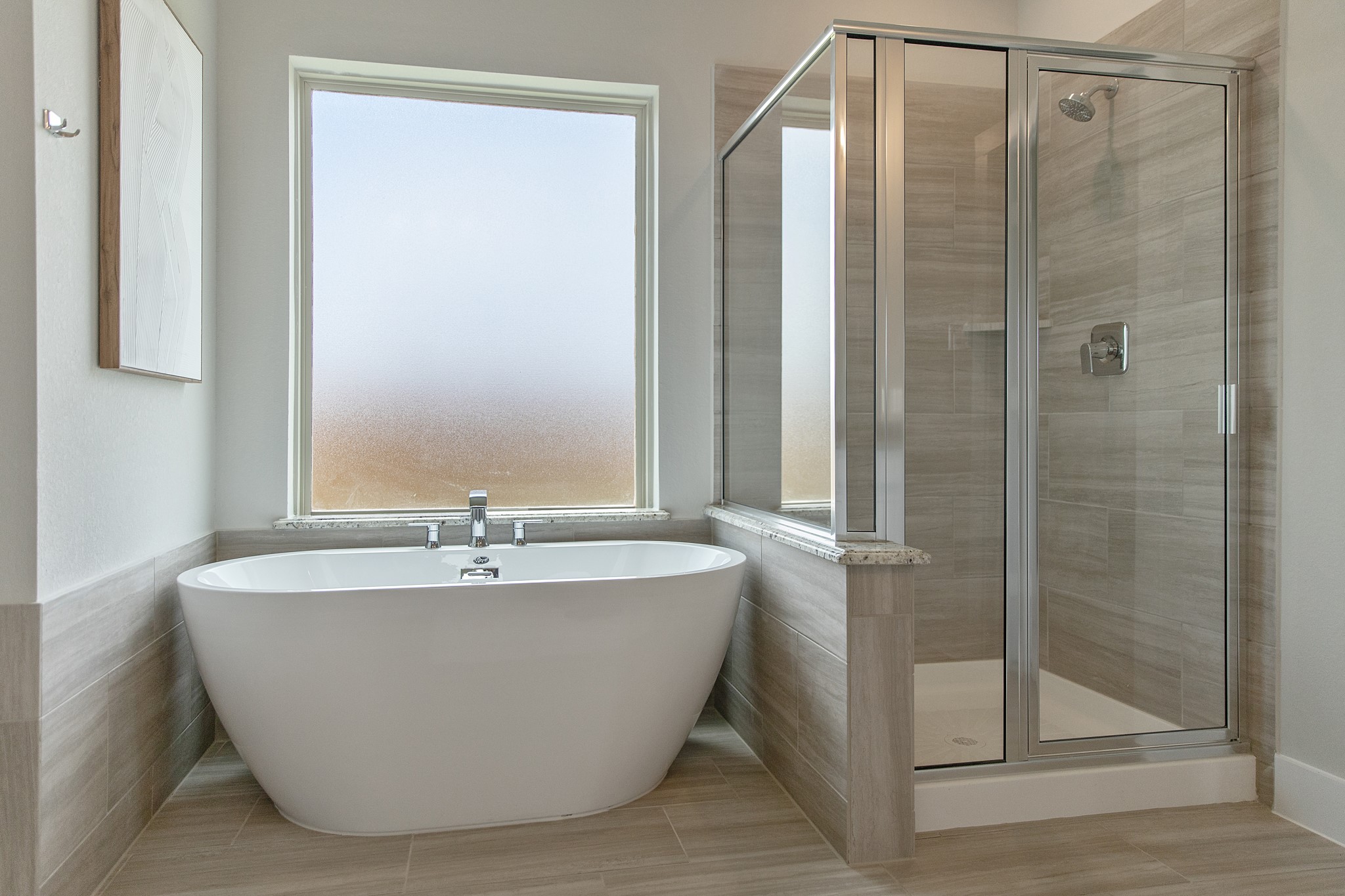 Indulge in a spa-like retreat within the confines of this primary bathroom. Delight in a spacious walk-in shower enveloped in stylish tile surround, unwind in a separate garden tub adorned with custom detailing.