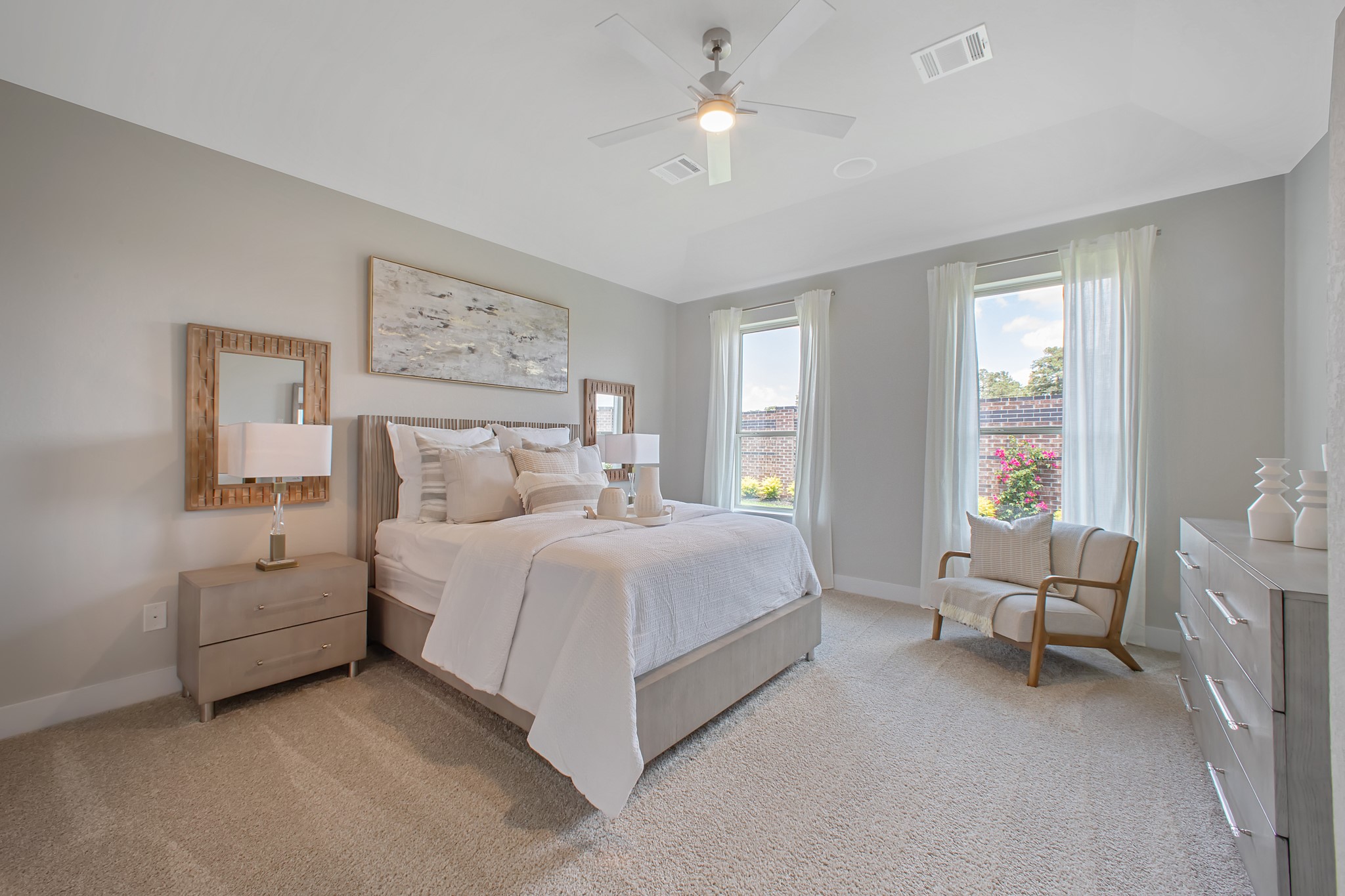 Escape and relax in the exquisite primary suite, a haven to unwind after a long day. The spacious room, located on first floor, boasts plush carpeting, soothing paint tones, high ceilings, and expansive windows adorned with privacy blinds.