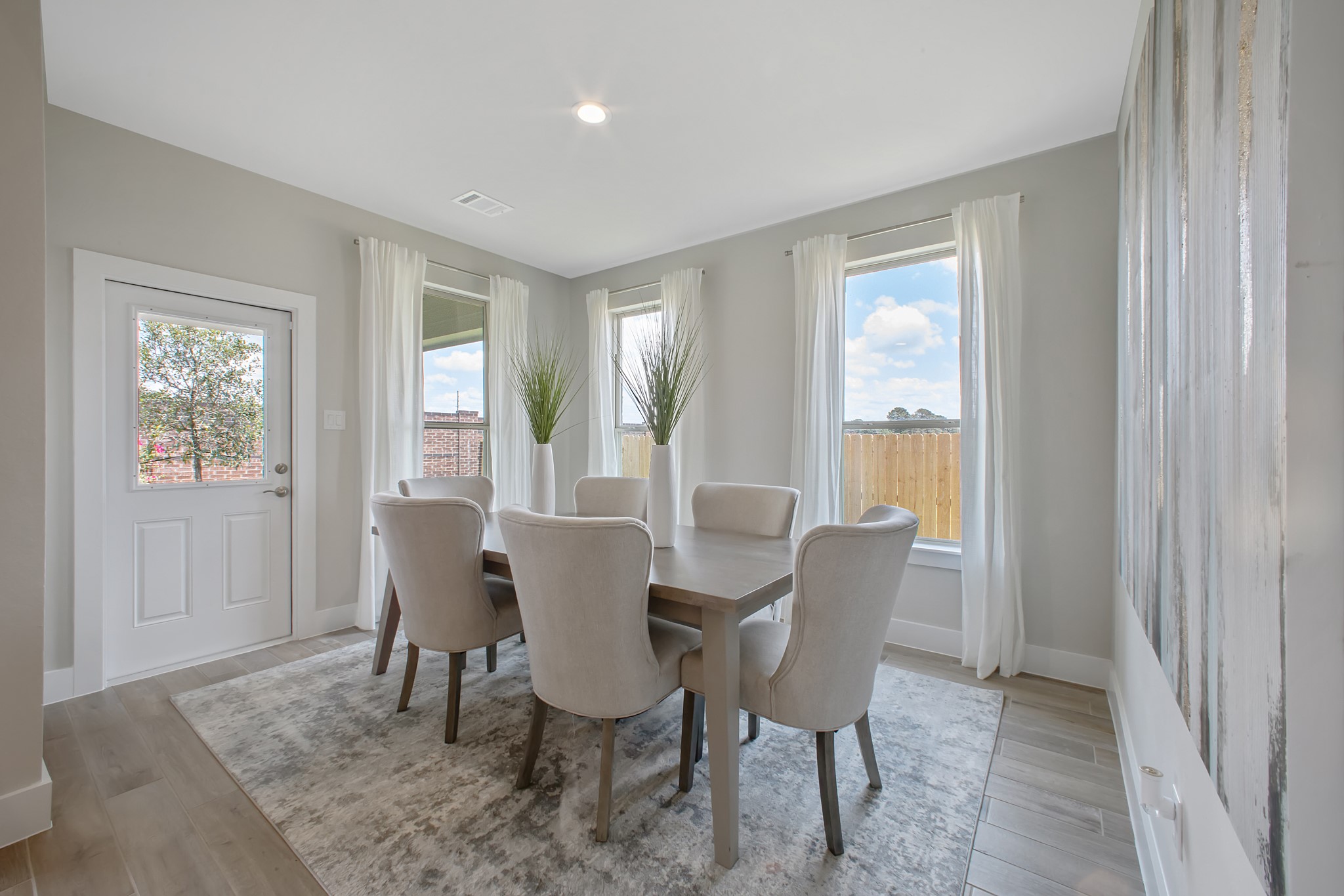 Create lasting memories with your family and friends at the dining table! This expansive dining room showcases sophisticated flooring, custom paint, and seamlessly connects to the family room and kitchen, providing an open and inviting atmosphere