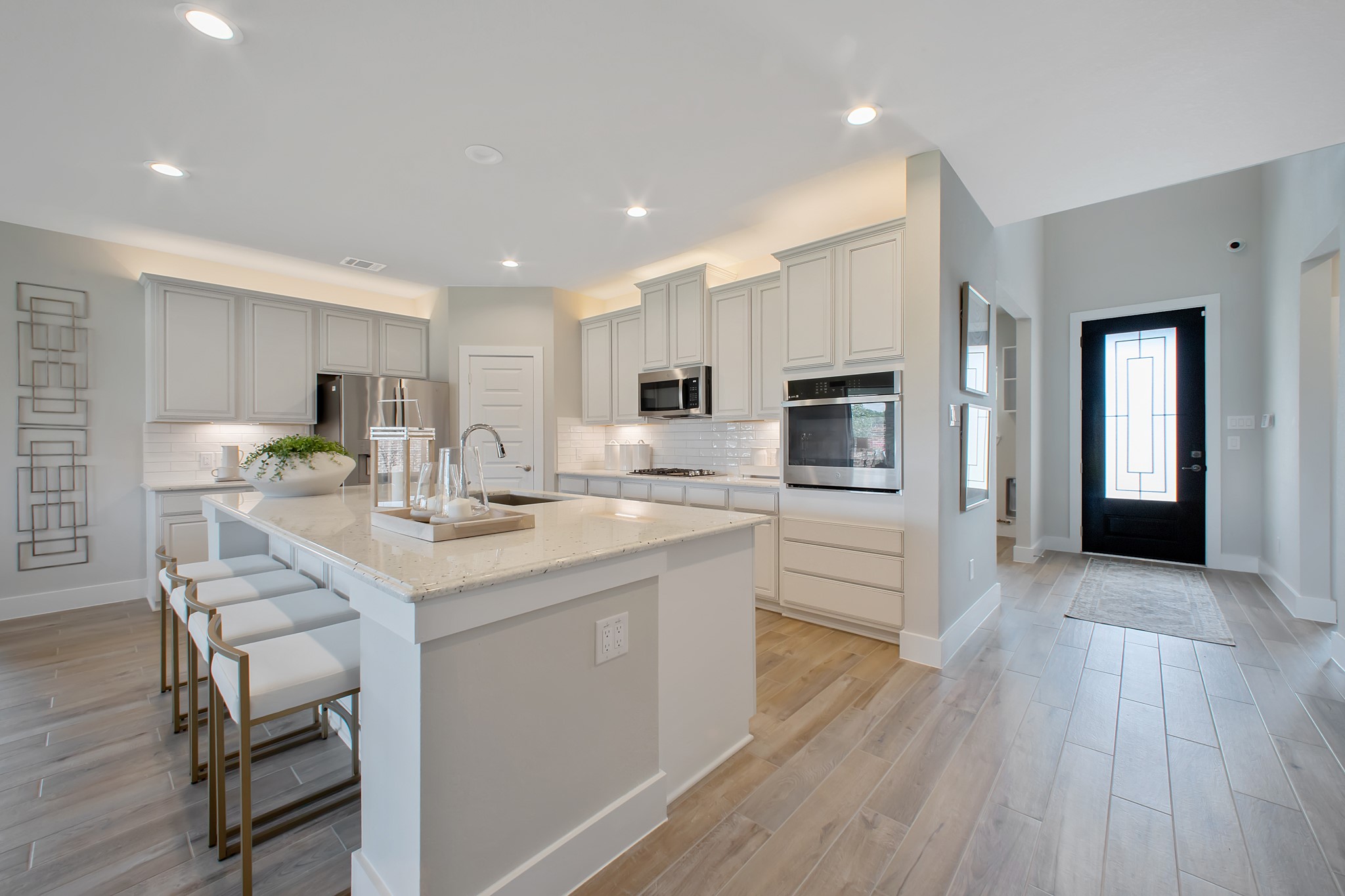 This kitchen is by far any chefs dream! This spacious kitchen features high ceilings, stained wood cabinets, granite countertop, SS appliances, modern tile backsplash, recessed lighting, extended counter space, granite kitchen island with double sink, and space for breakfast bar, and a walk-in pantry all overlooking your huge family room.