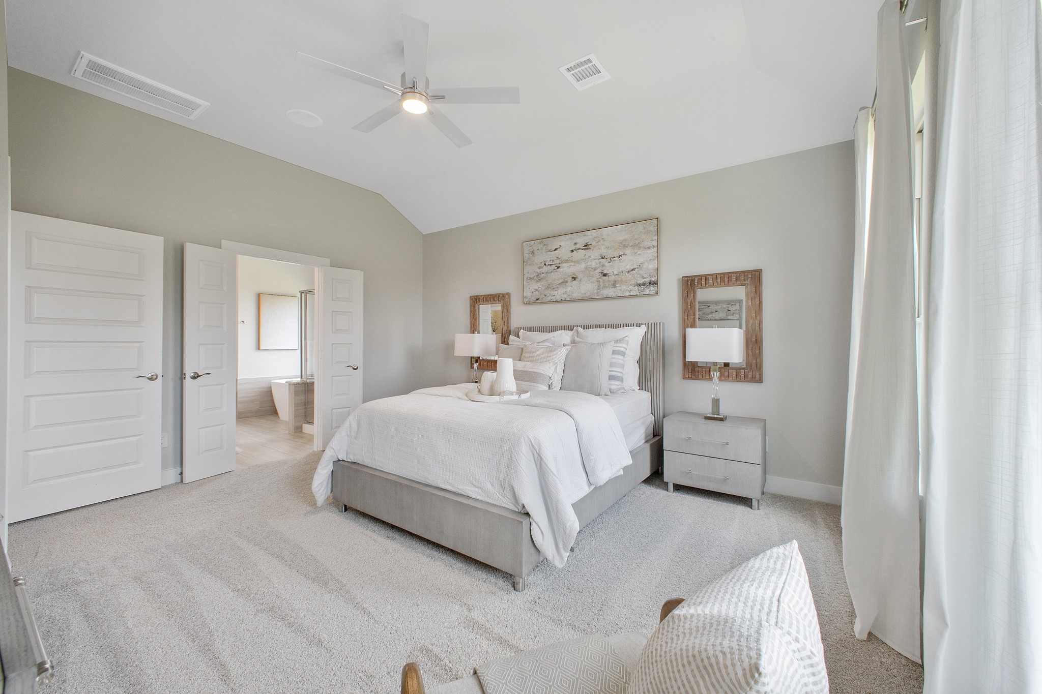 Retreat to the luxurious primary suite, your perfect escape for unwinding after a long day. Located on the first floor, this spacious room features plush carpeting, calming paint tones, high ceilings, and large windows with privacy blinds.