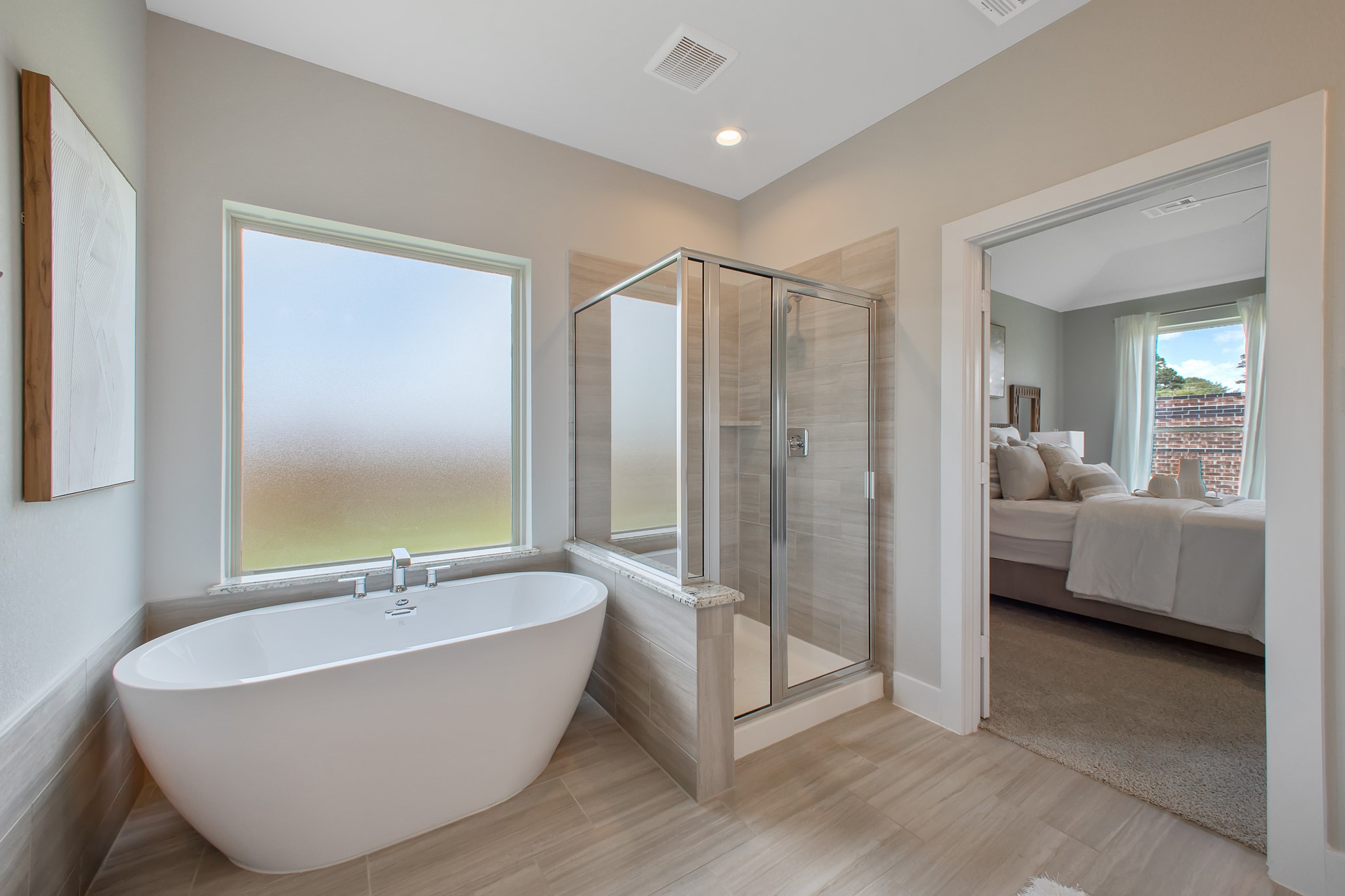 Indulge in a spa-like retreat within the confines of this primary bathroom. Delight in a spacious walk-in shower enveloped in stylish tile surround, unwind in a separate garden tub adorned with custom detailing.