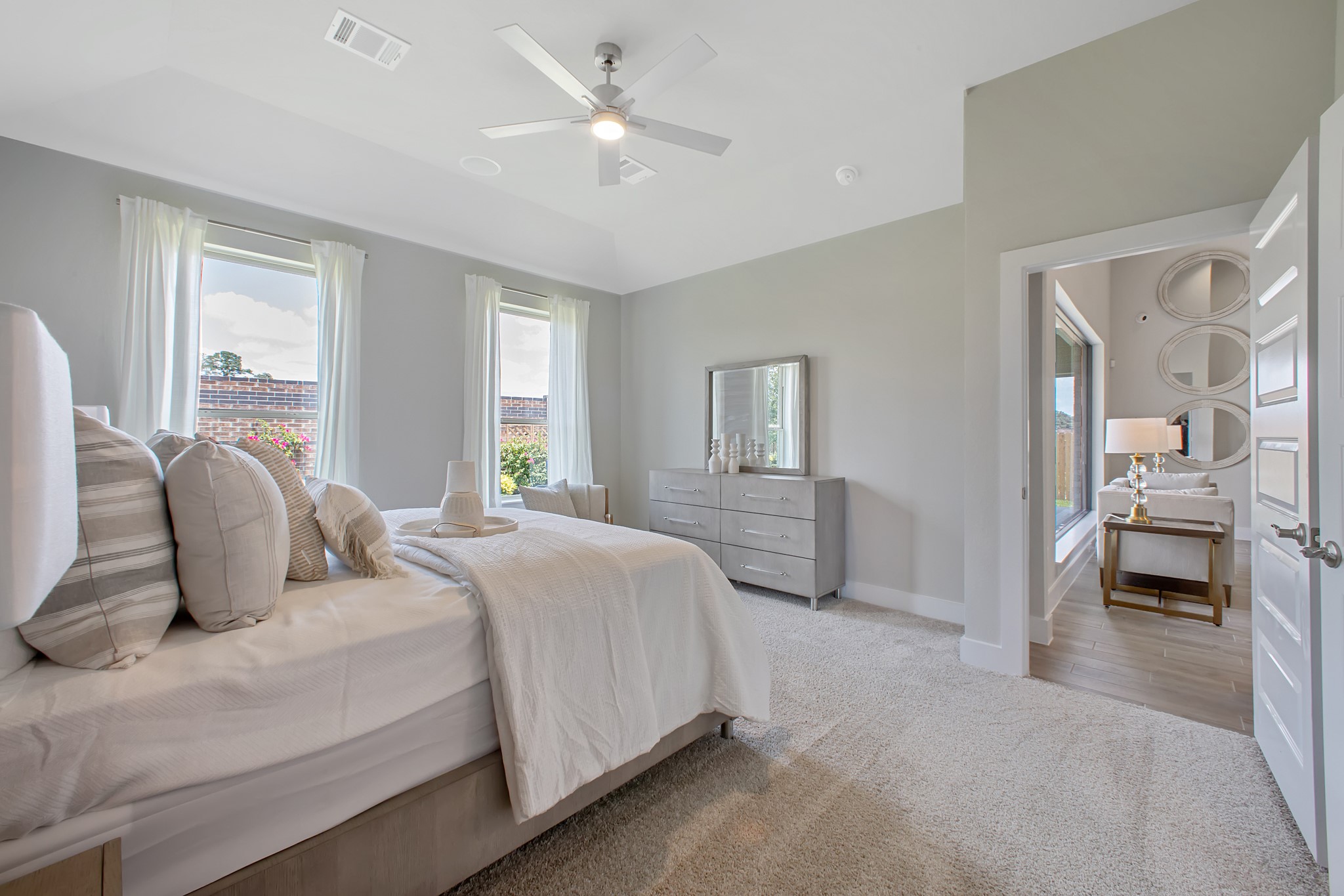 Escape to tranquility in this spacious primary room, adorned with plush carpeting and bathed in the soothing hues of warm paint colors, creating a cozy retreat for relaxation.