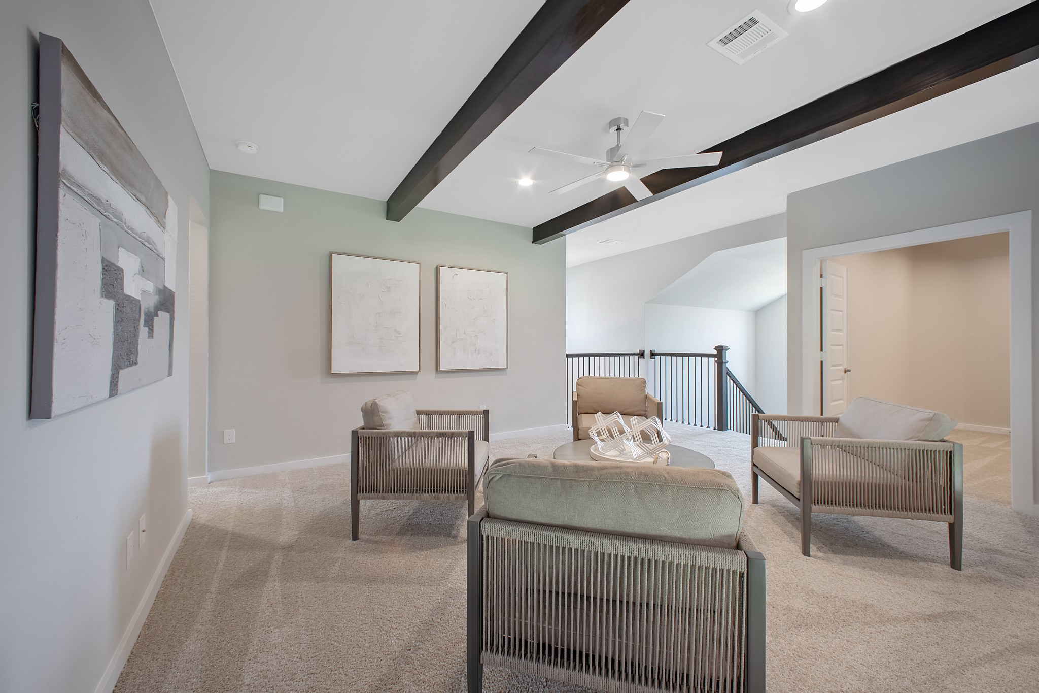 Come upstairs and relish a day of relaxation in this loft area! Ideal as an additional living space or game room, it boasts plush carpeting, high ceilings, custom paint, and windows that flood the area with abundant natural light.