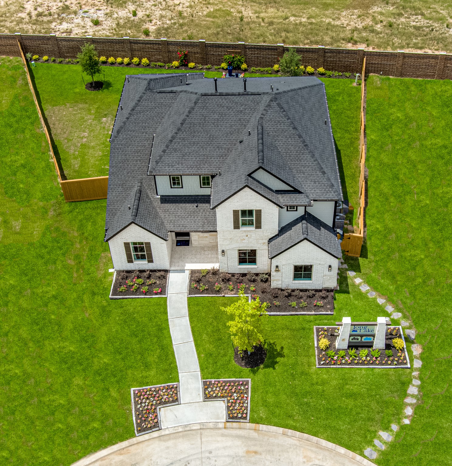 An aerial view of a spacious subdivision lot, highlighting a well-maintained yard and a fully fenced perimeter, offering both privacy and expansive outdoor space.