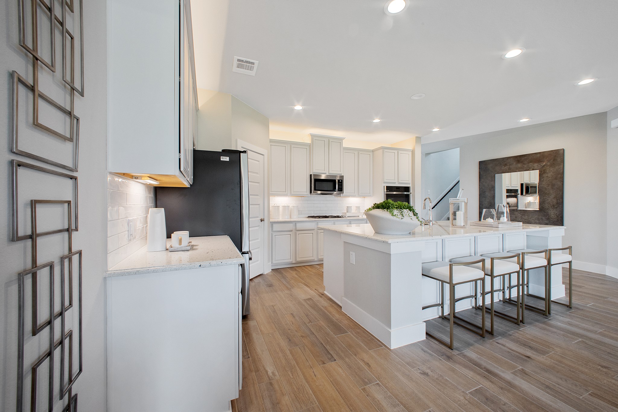 Step into a dream realized with this generously spacious kitchen! A massive granite island takes center stage, complemented by high ceilings and soft-close cabinets. The granite countertops, stainless steel appliances, sleek tile backsplash, and recessed lighting complete the elegant design.