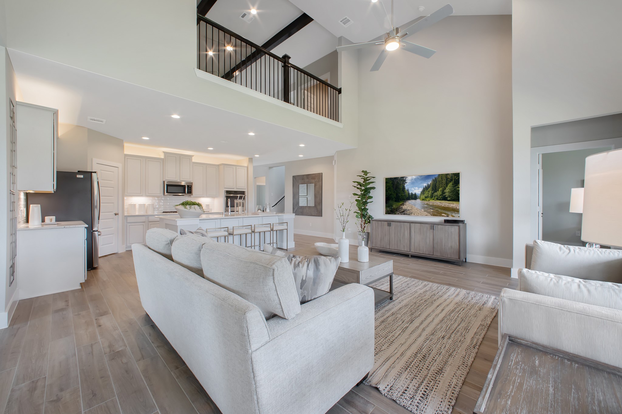 Welcome family and guests to your charming living room! With its high ceilings, recessed lighting, ceiling fan, custom paint, beautiful flooring, and large windows that let in abundant natural light, this room is perfect for gatherings.