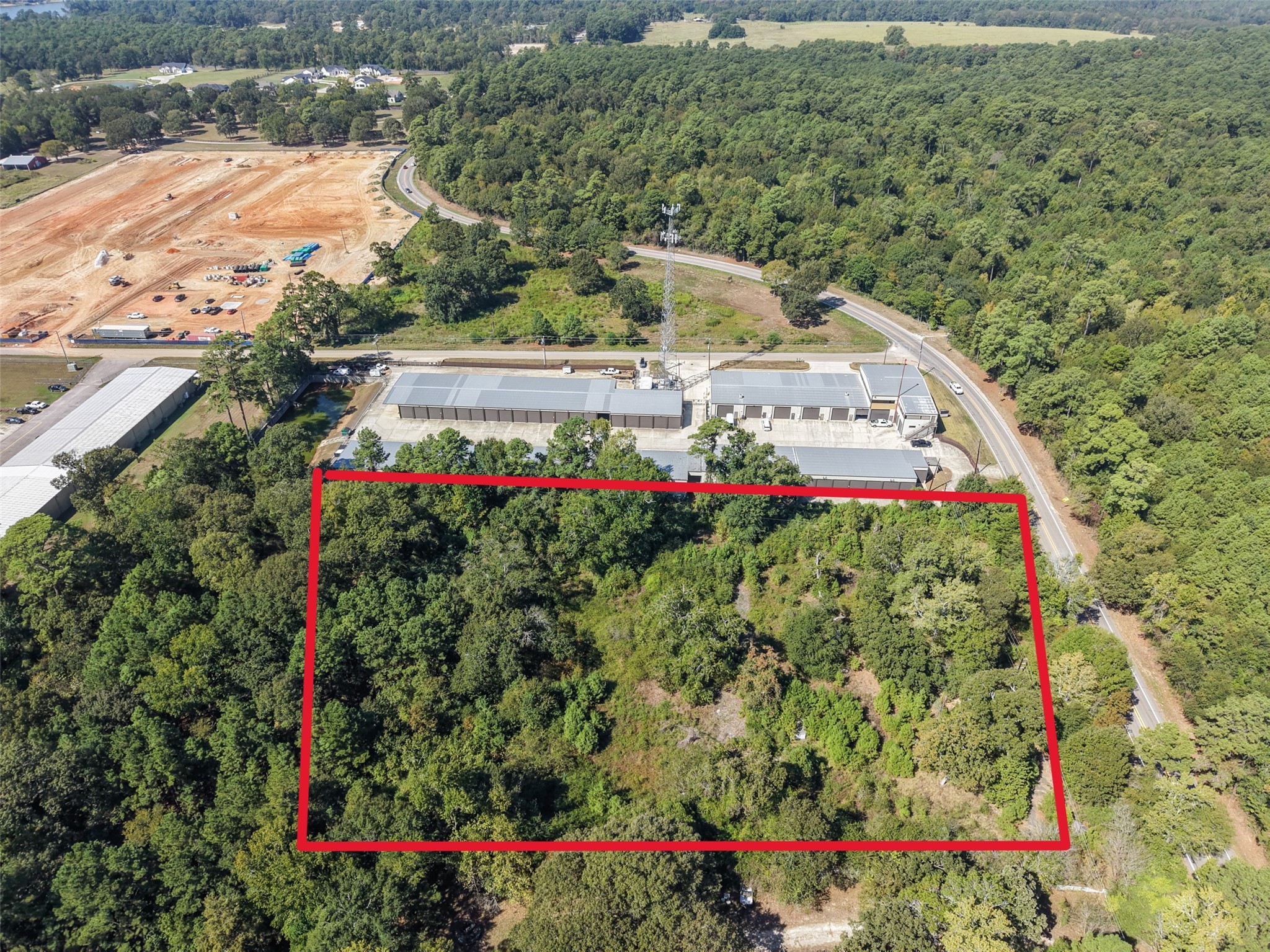 Elevated aerial perspective showcasing the property's layout, mature trees, and proximity to neighboring commercial facilities. Nearby development activity highlights the area's evolving landscape. Elevated aerial perspective showcasing the property's layout, mature trees, and proximity to neighboring commercial facilities. Nearby development activity highlights the area's evolving landscape.