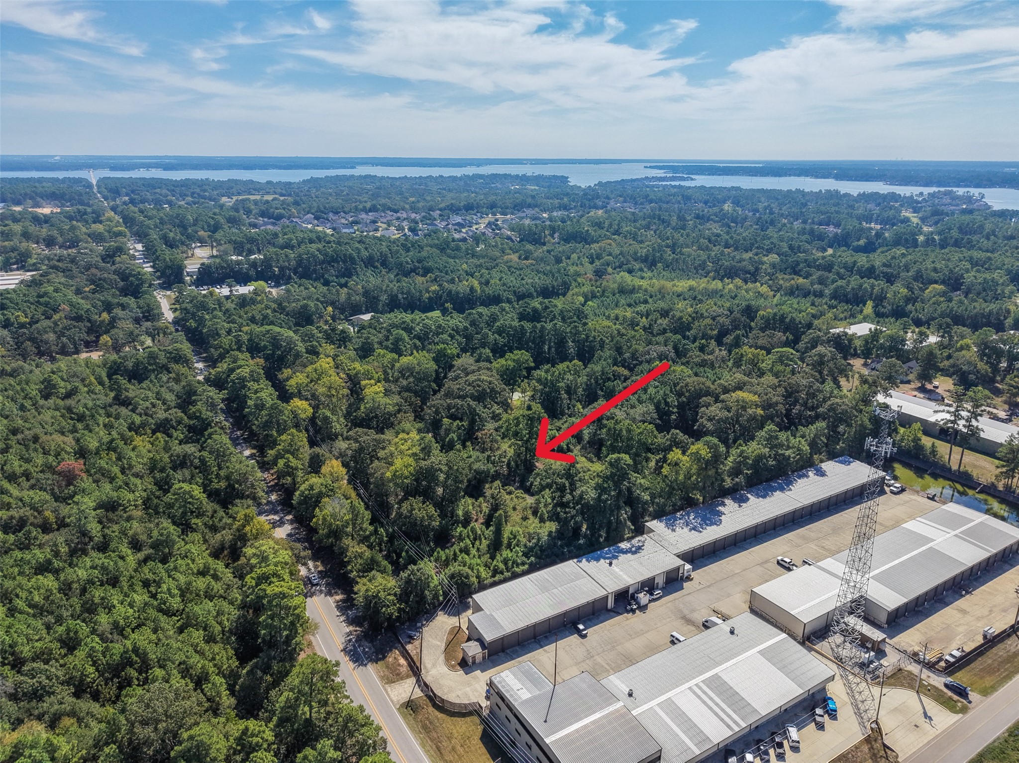 Scenic aerial view highlighting the property's location among mature trees, established commercial facilities, and nearby Lake Conroe. The surrounding area offers a blend of natural beauty and accessibility. Scenic aerial view highlighting the property's location among mature trees, established commercial facilities, and nearby Lake Conroe. The surrounding area offers a blend of natural beauty and accessibility.