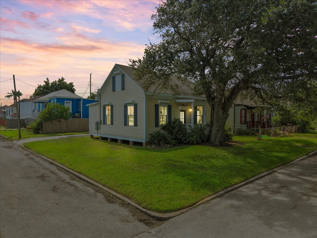 Evening exterior view with mature trees framing the property.