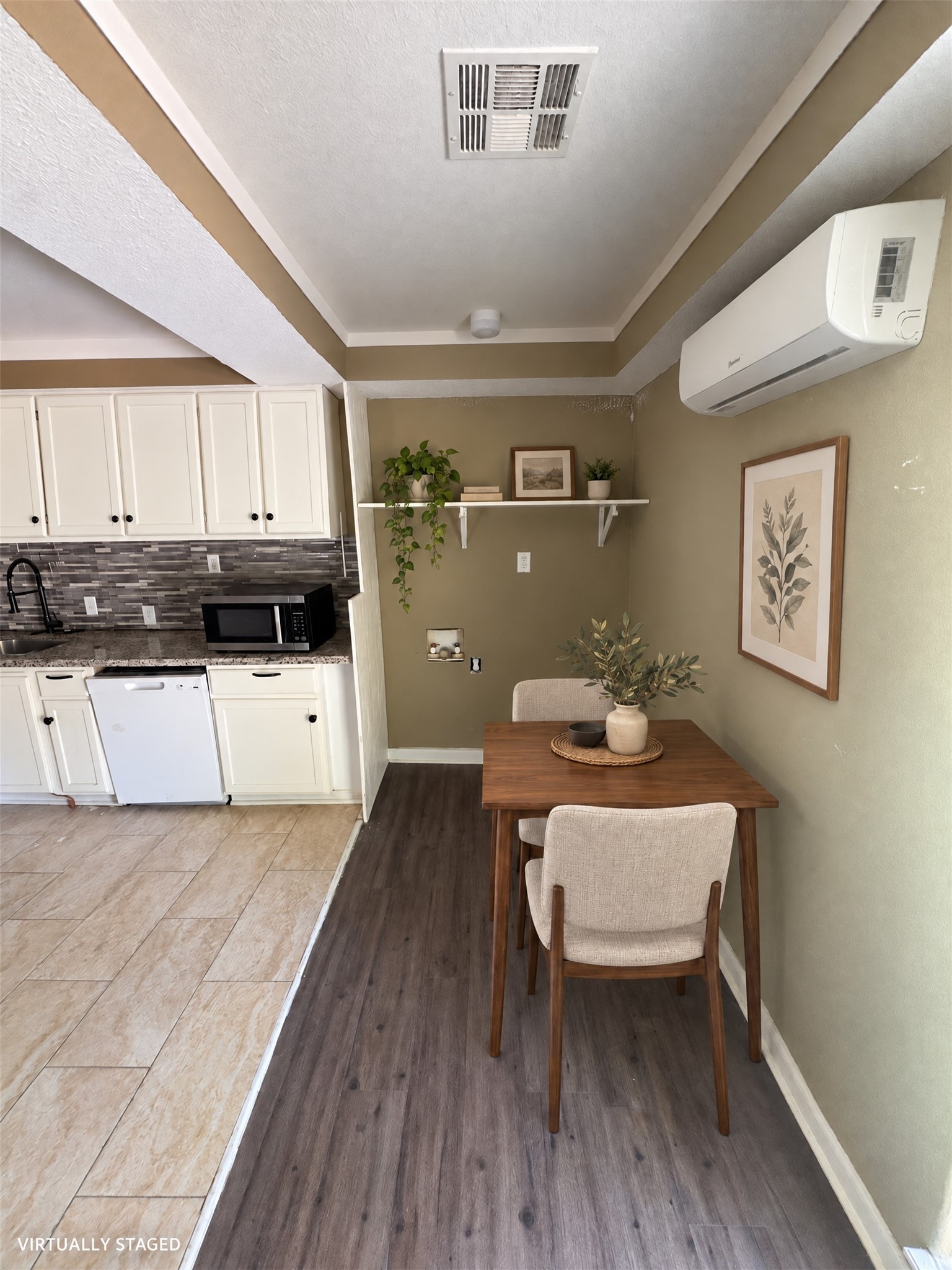Virtually staged: a compact table and two chairs show a dining arrangement beside the kitchen. Virtually staged: a compact table and two chairs show a dining arrangement beside the kitchen.