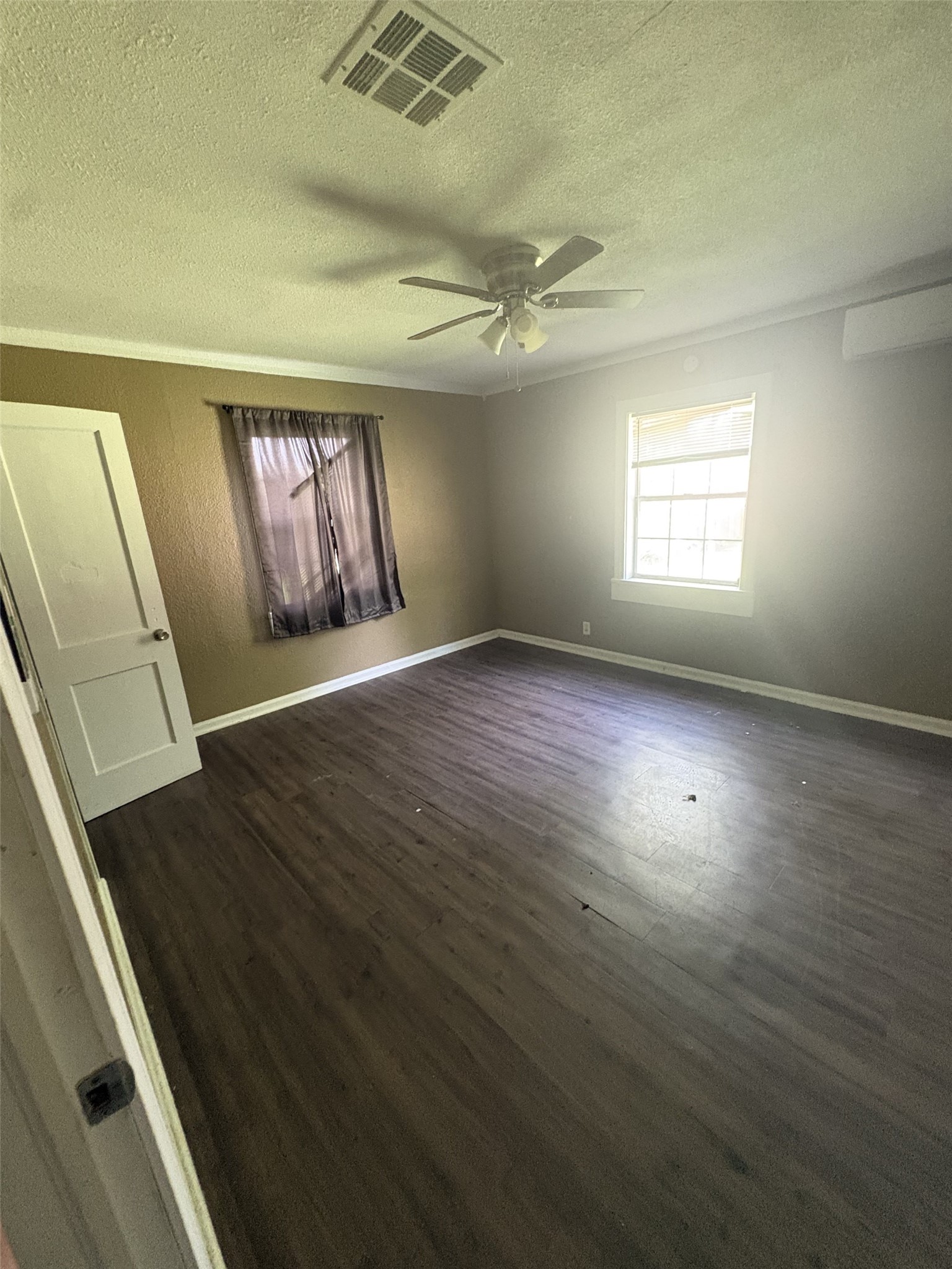Another room features two windows, a ceiling fan, and wood-look flooring. Another room features two windows, a ceiling fan, and wood-look flooring.