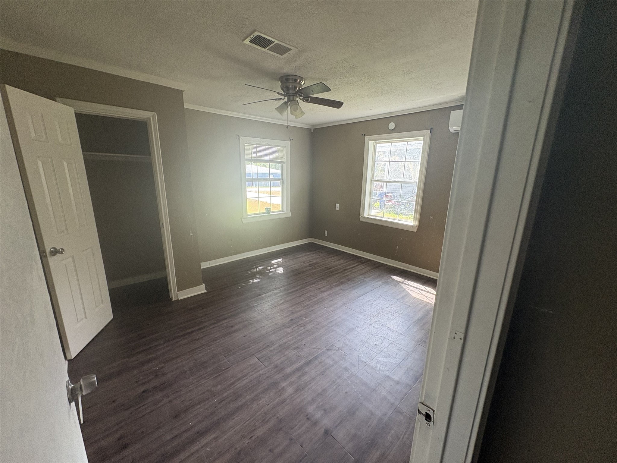 Two windows and an open closet bring light and storage to this room. Two windows and an open closet bring light and storage to this room.
