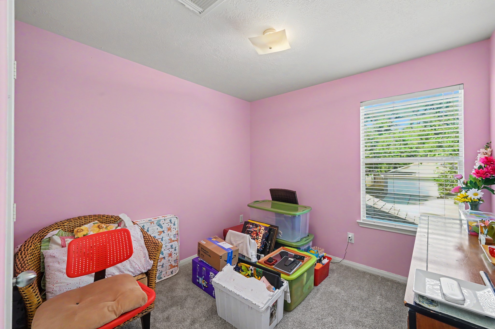 Bedroom with cozy carpet, and abundant natural light, perfect for relaxation.