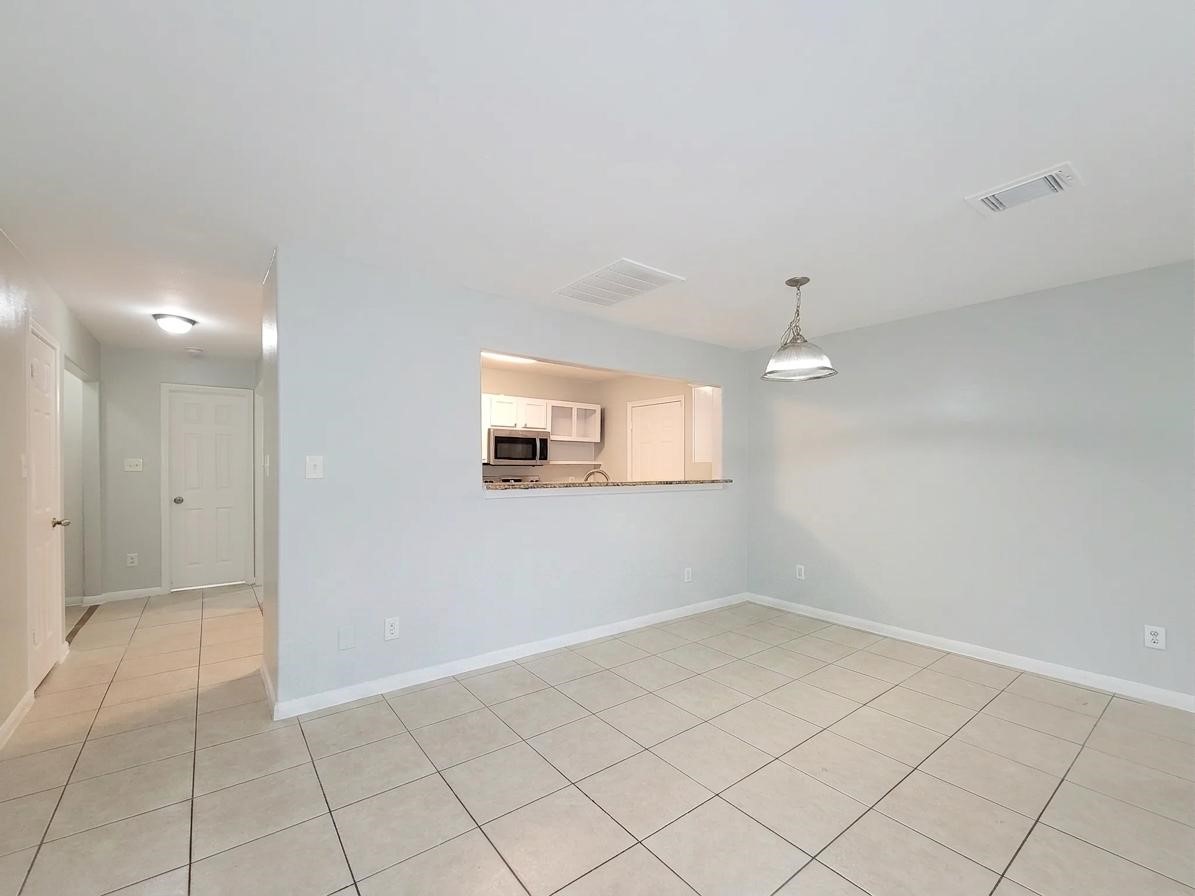 Bright, open living space with tiled floors and a modern kitchen pass-through, perfect for easy entertaining.