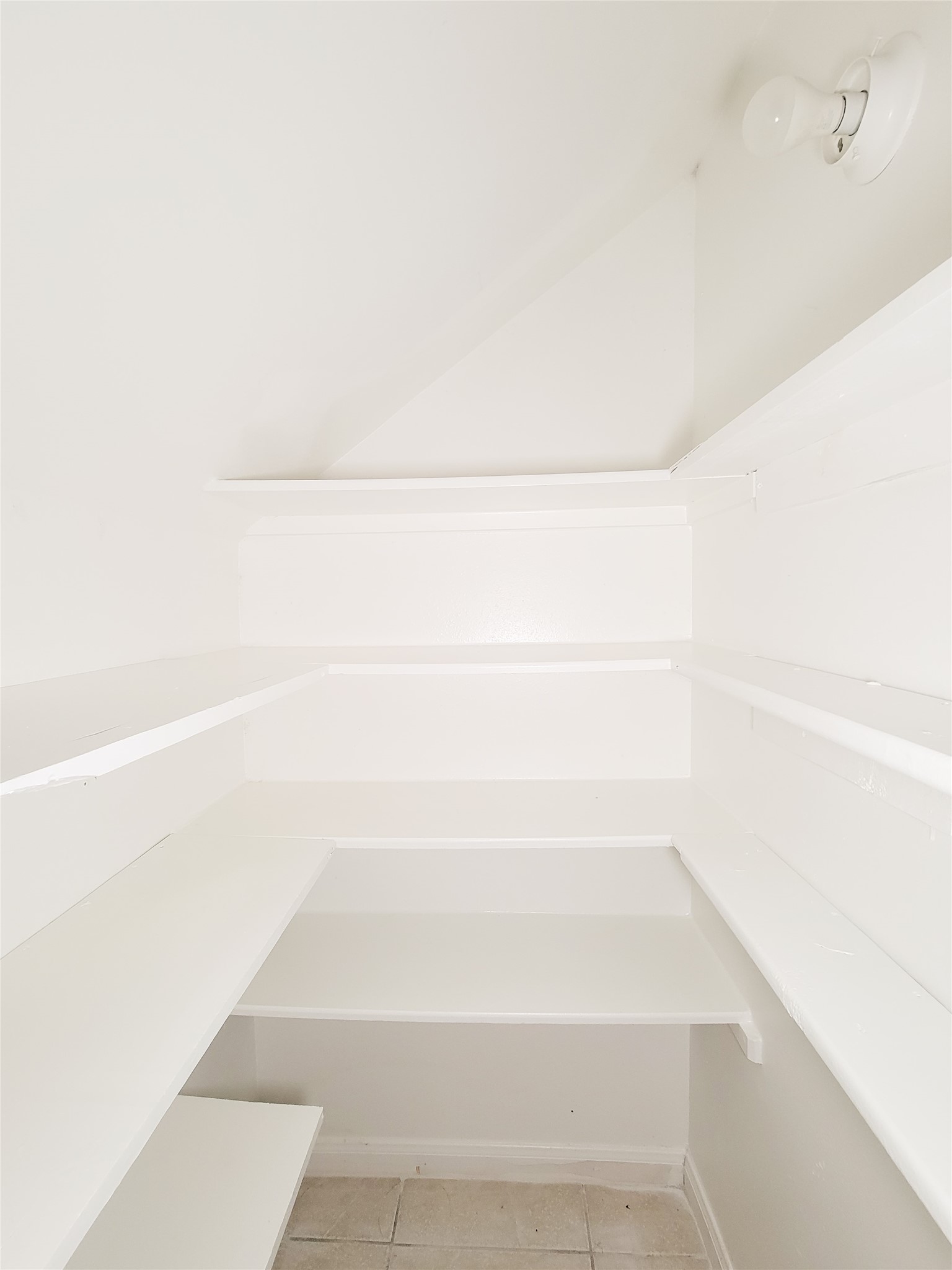 Spacious walk-in pantry with ample shelving and a clean, bright design, perfect for organized storage.