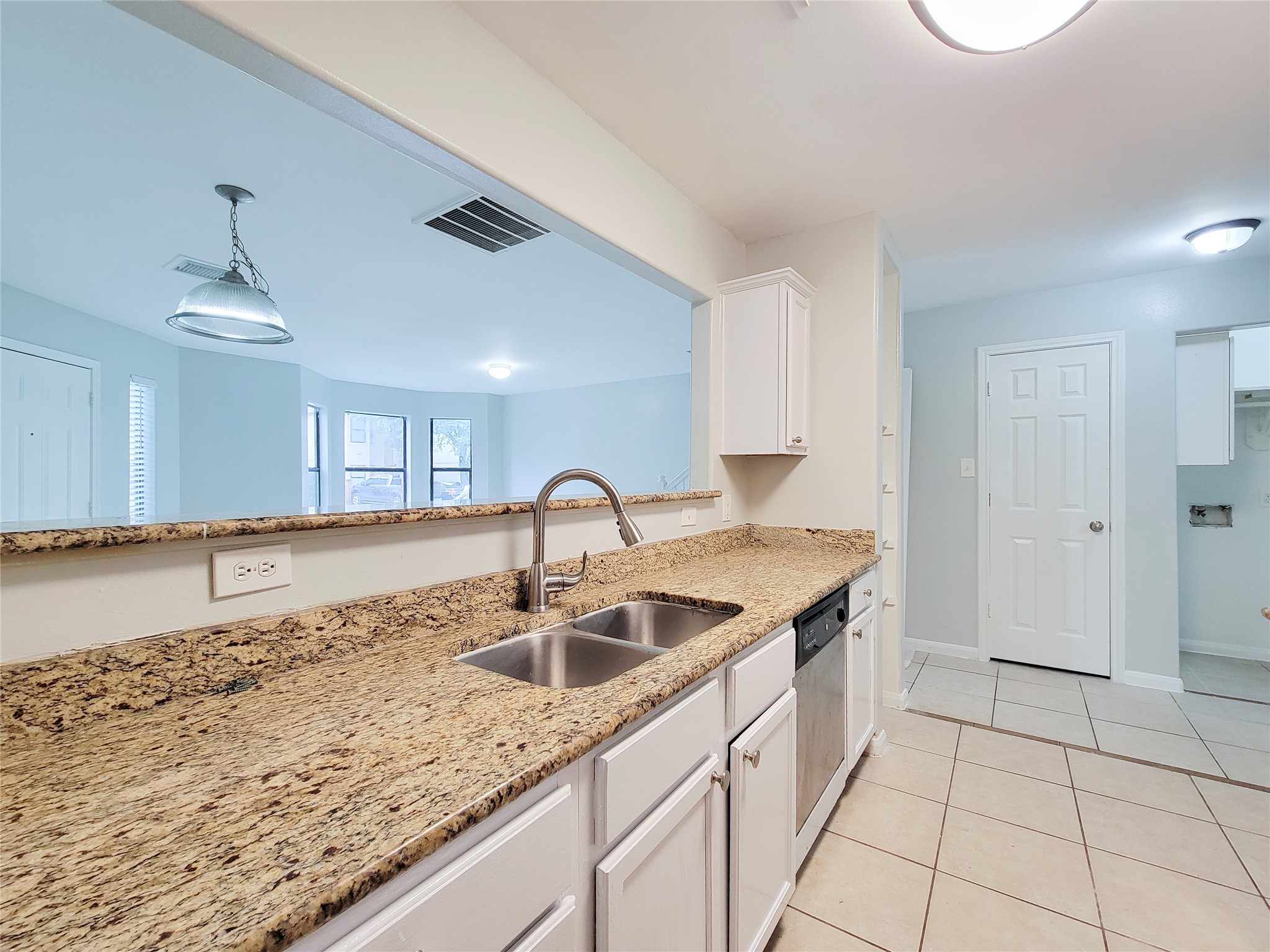 Spacious kitchen with elegant granite countertops, stainless steel appliances, and an open layout overlooking a bright living area.