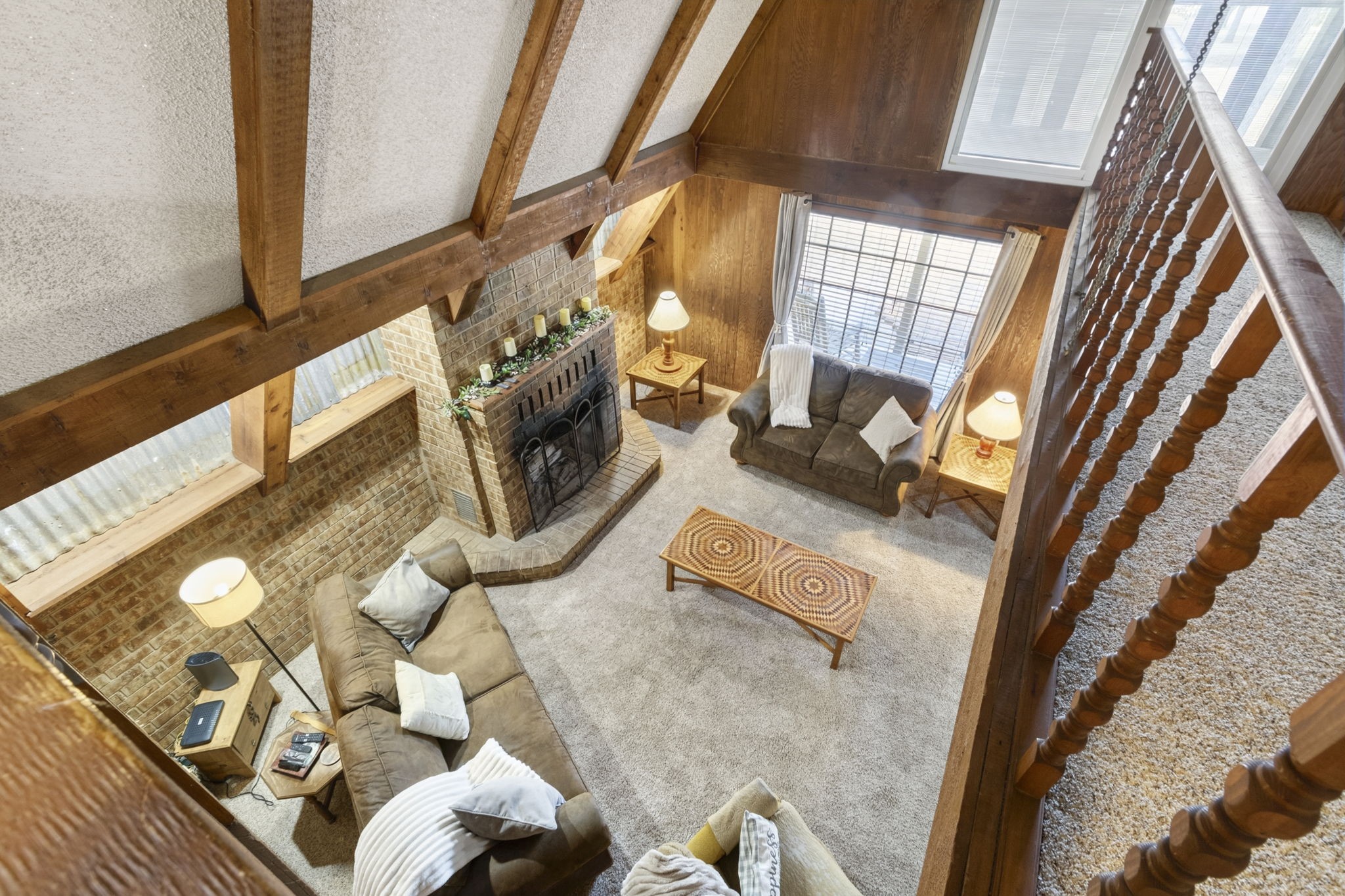 Now, lets head upstairs.
Take in an impressive view overlooking the spacious main living area, highlighting the homes open design, soaring ceilings, and unique character.