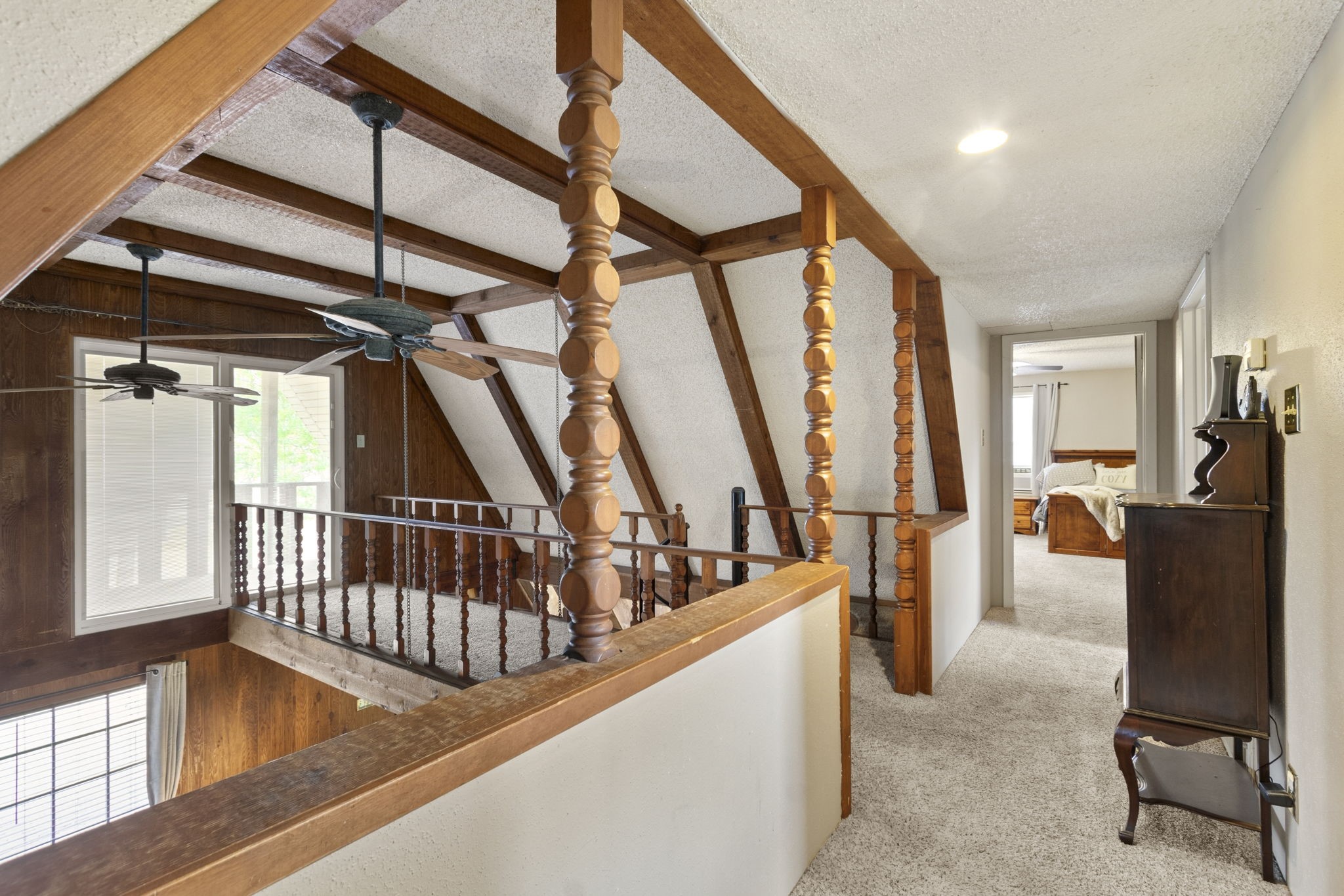 Step onto the upstairs walkway leading to the outdoor balcony.
The open doorway ahead welcomes you into one of two generously sized upstairs bedrooms.